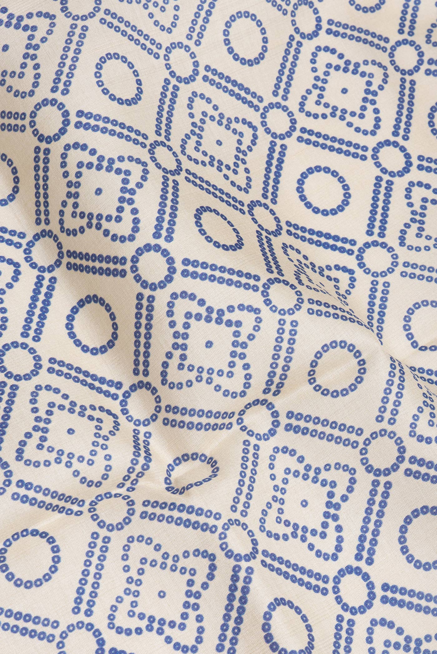 Close up of Beige Tussar Silk Saree with Bandhani Print on the body and Fancy Border.  displaying folds
