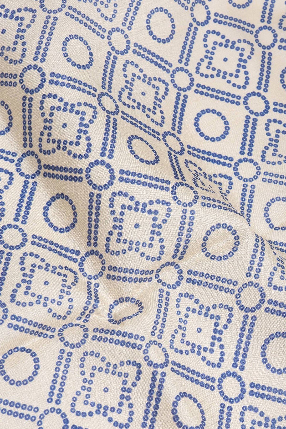 Close up of Beige Tussar Silk Saree with Bandhani Print on the body and Fancy Border.  displaying folds