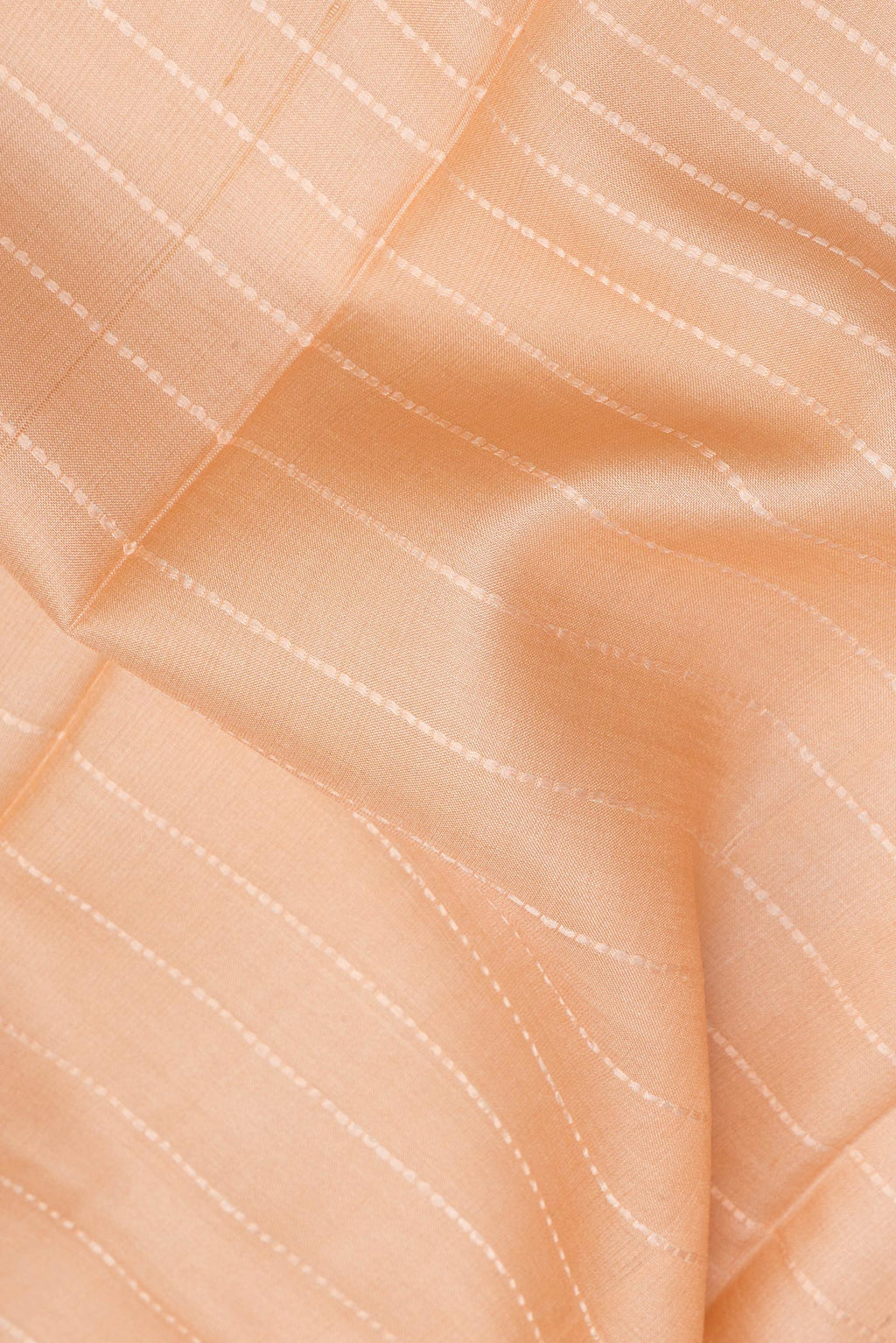 Close up of Pure Silk Peach Dual Tone Tussar Saree with Stripes on the body and Fancy Border.  displaying folds