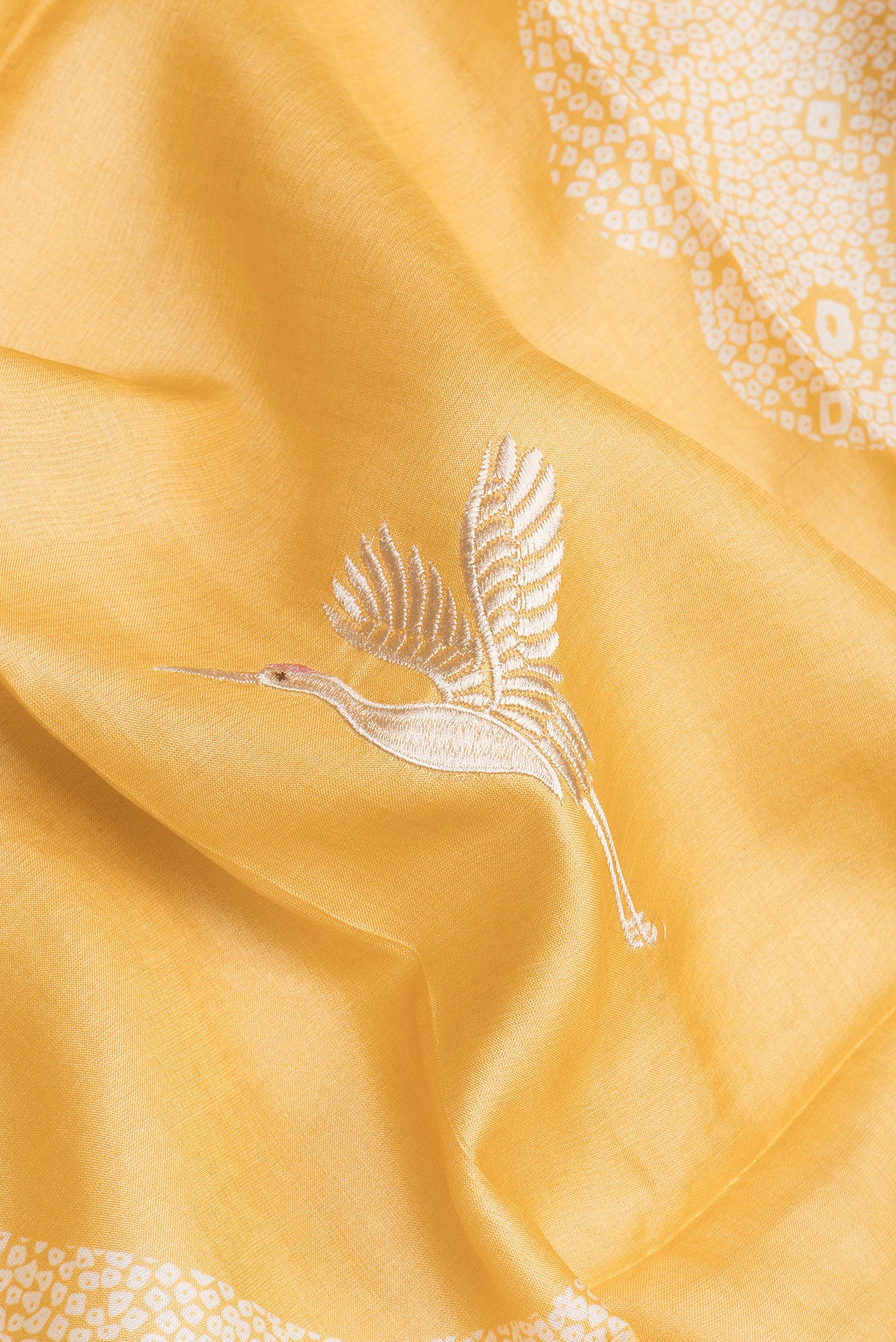 Close up of Yellow Tussar Silk Saree with Embroidery on the body and Embroidery Border.  displaying folds