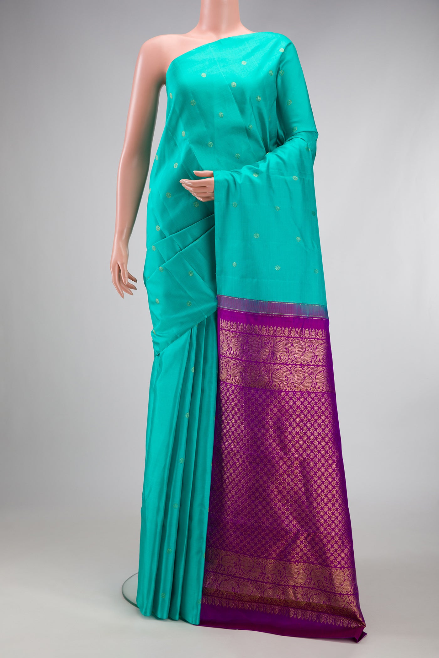 Turquoise Kanchipuram Silk Saree with Zari Butta on the body and Without Border.  displayed on a mannequin