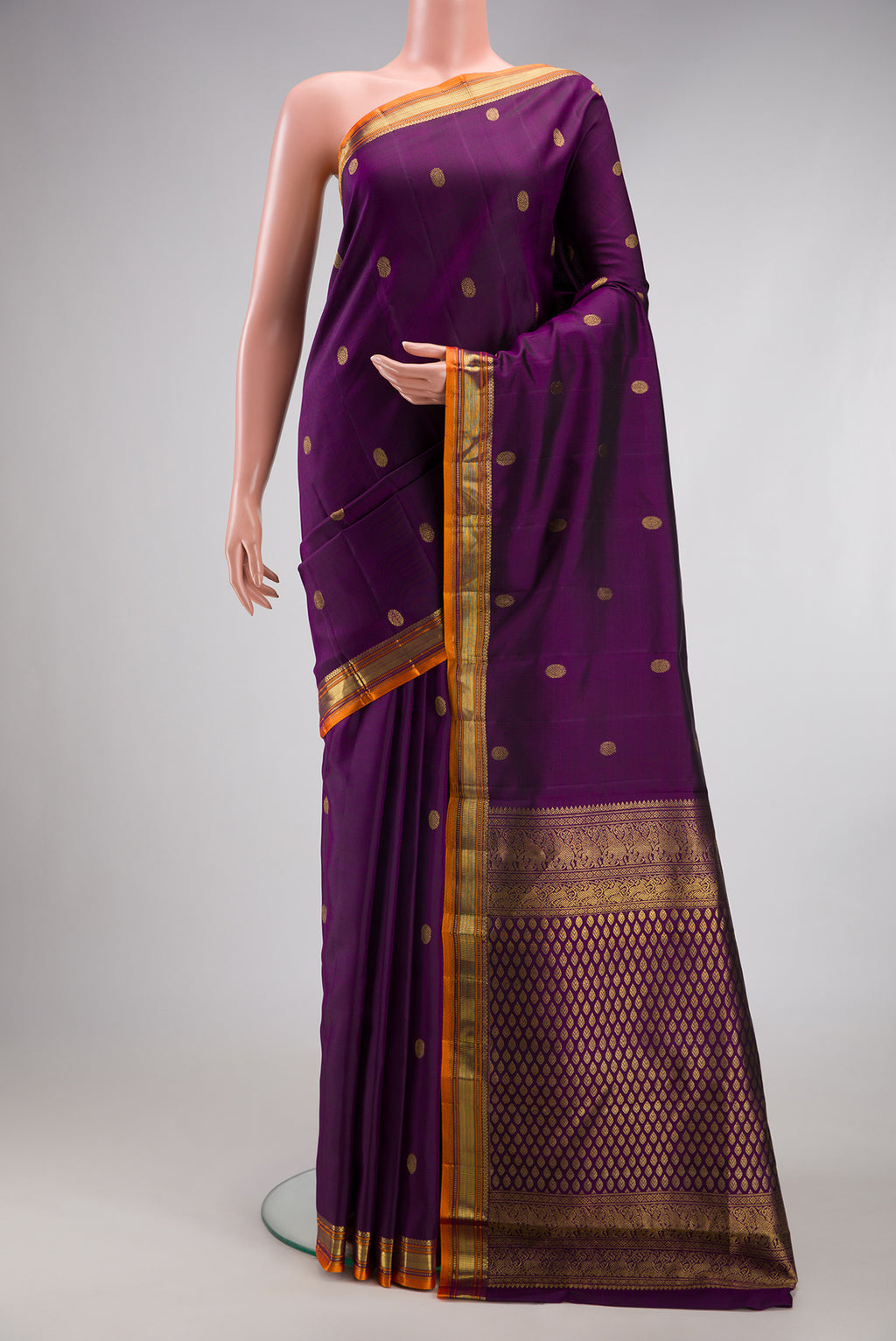 Violet Kanjivaram Silk Saree with Zari Butta on the body and Zari Border.  displayed on a mannequin