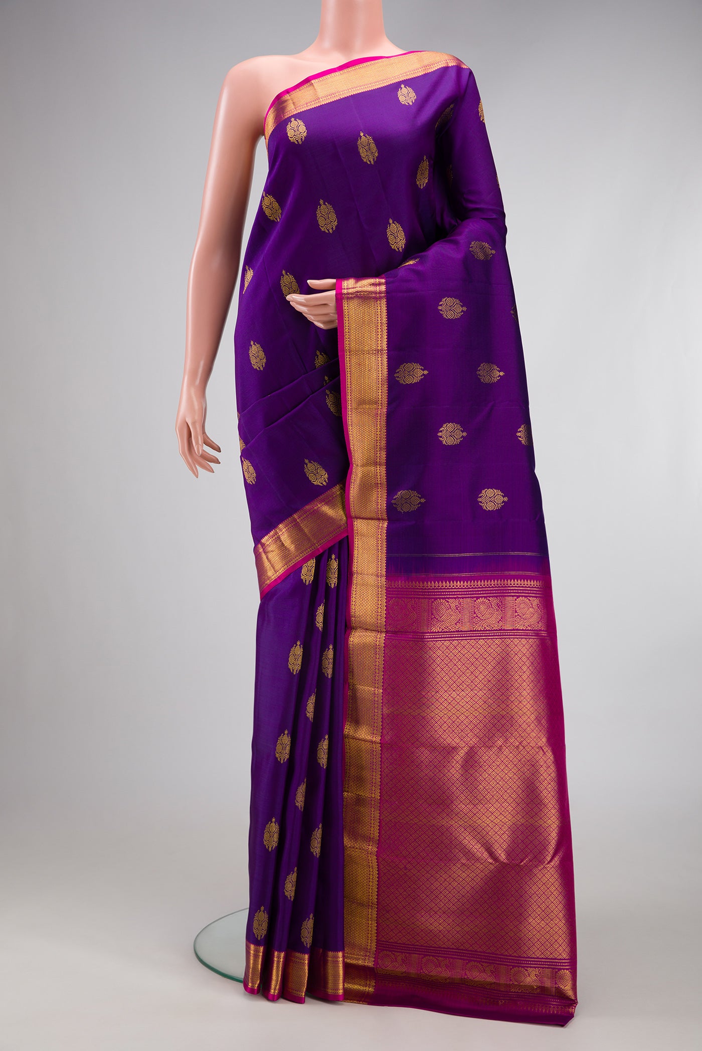 Violet Kanjivaram Silk Saree with Zari Butta on the body and Zari Border.  displayed on a mannequin