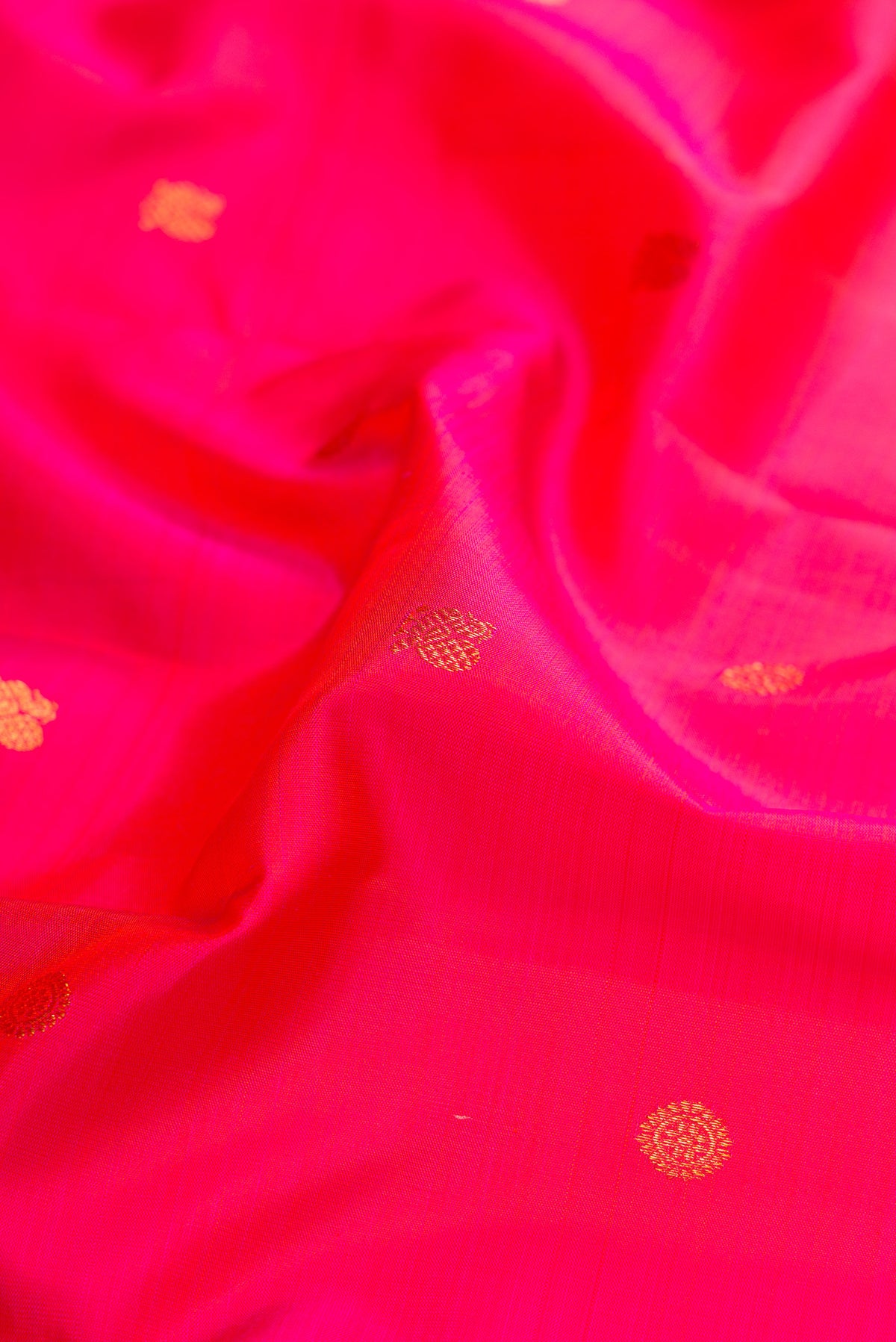Close up of Pink Dual Tone Kanjivaram Silk Saree with Zari Butta on the body and Zari Border.  displaying folds