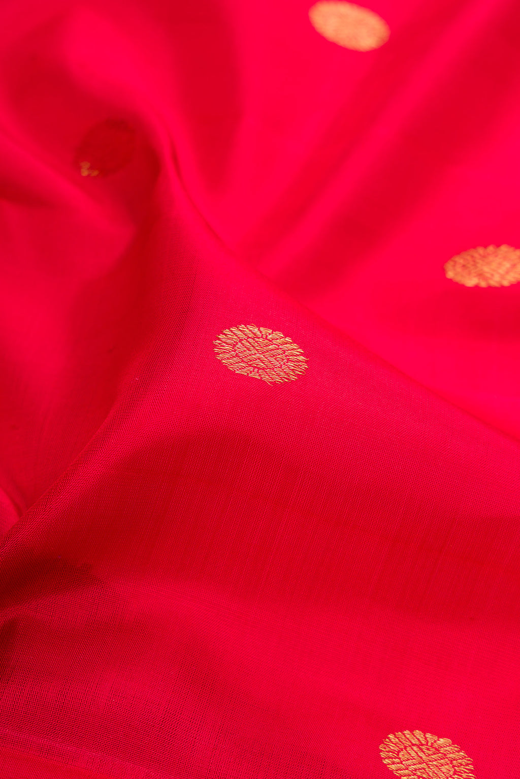 Close up of Red Kanjivaram Silk Saree with Zari Butta on the body and Zari Border.  displaying folds