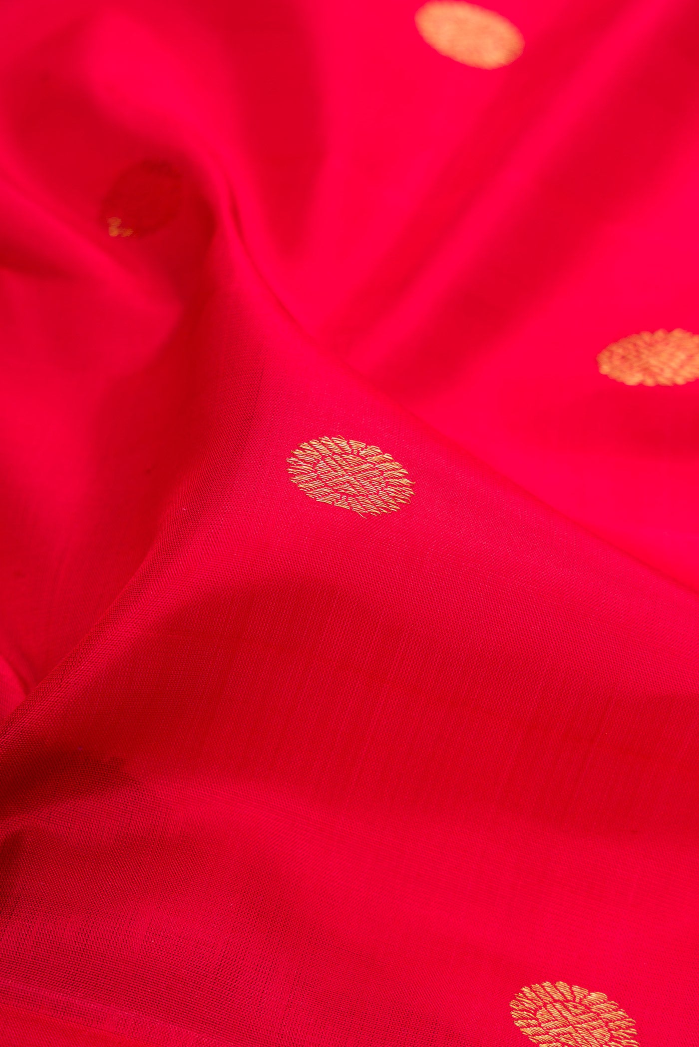 Close up of Red Kanjivaram Silk Saree with Zari Butta on the body and Zari Border.  displaying folds