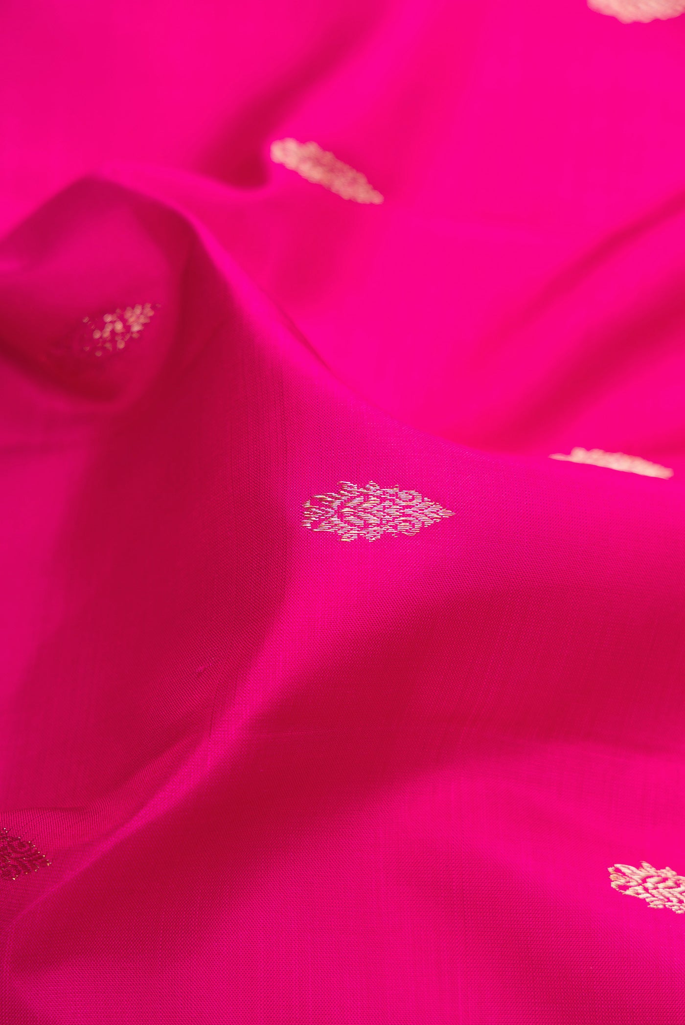 Close up of Pink Kanjivaram Silk Saree with Zari Butta on the body and Zari Border.  displaying folds