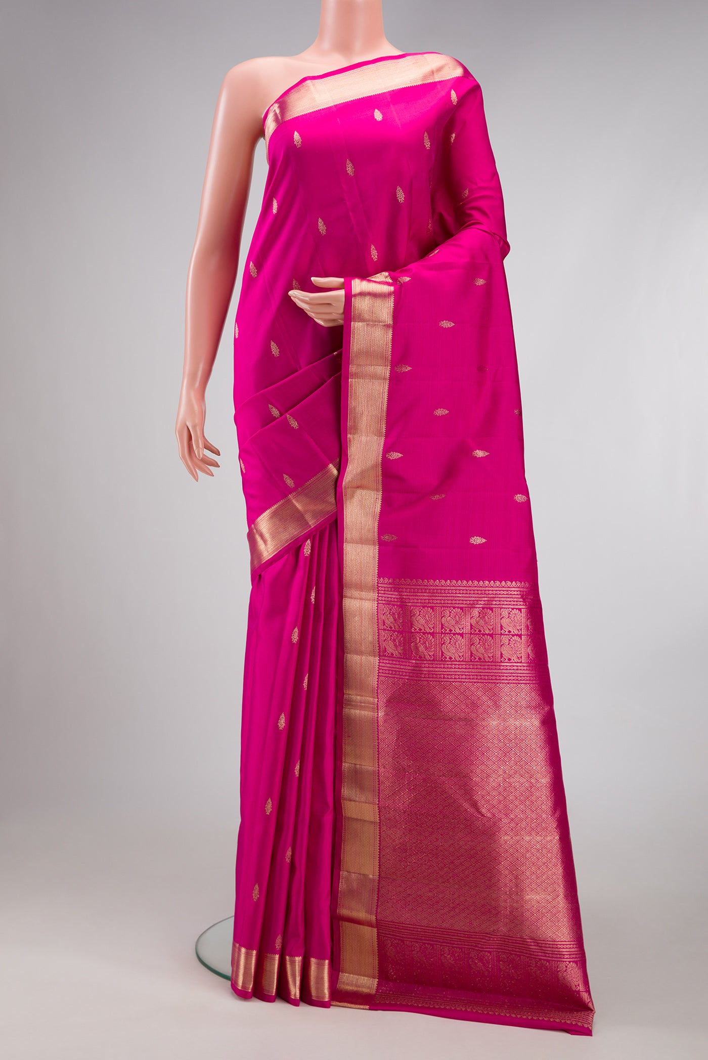 Pink Kanjivaram Silk Saree with Zari Butta on the body and Zari Border.  displayed on a mannequin