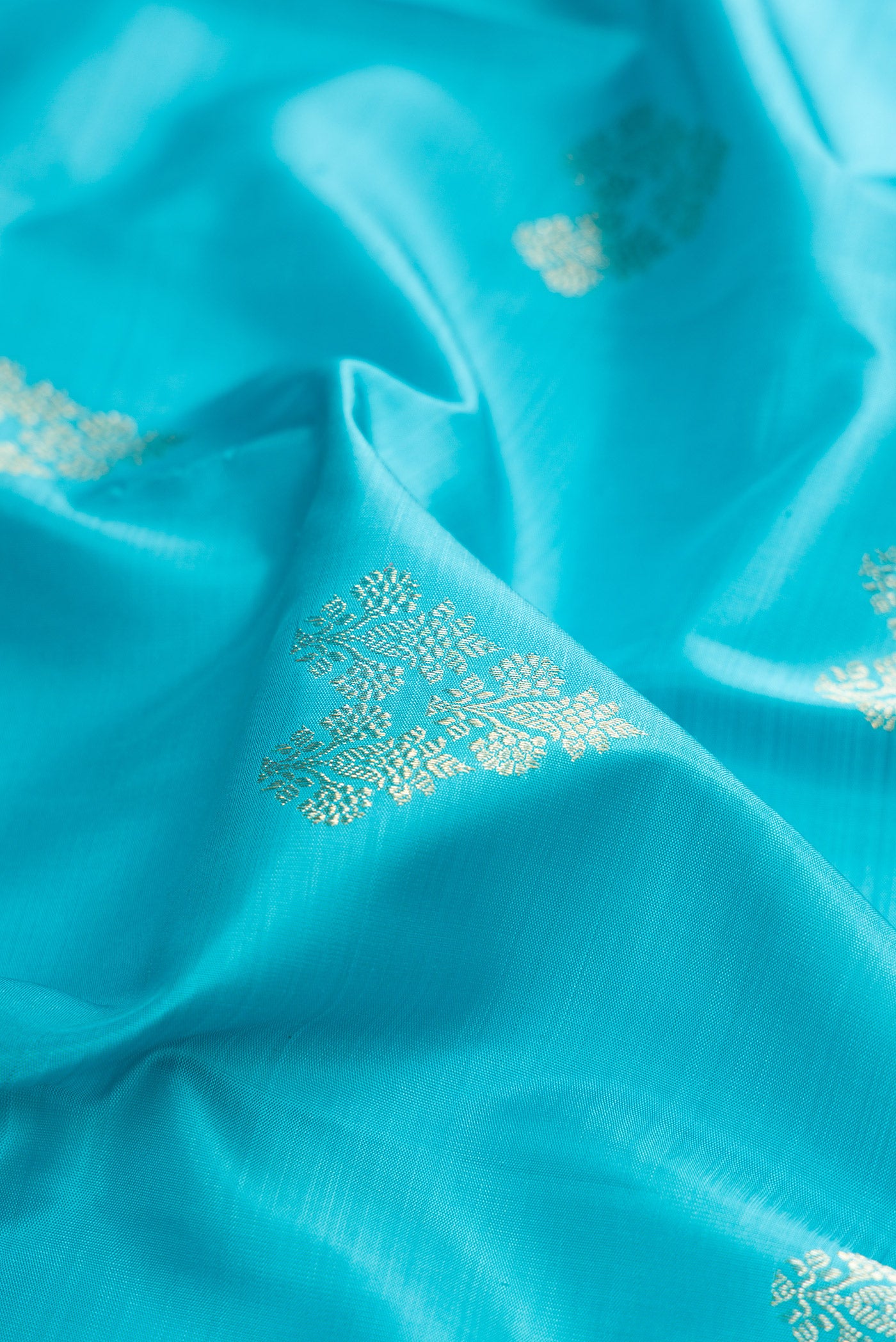 Close up of Light Blue Kanjivaram Silk Saree with Zari Butta on the body and Zari Border.  displaying folds