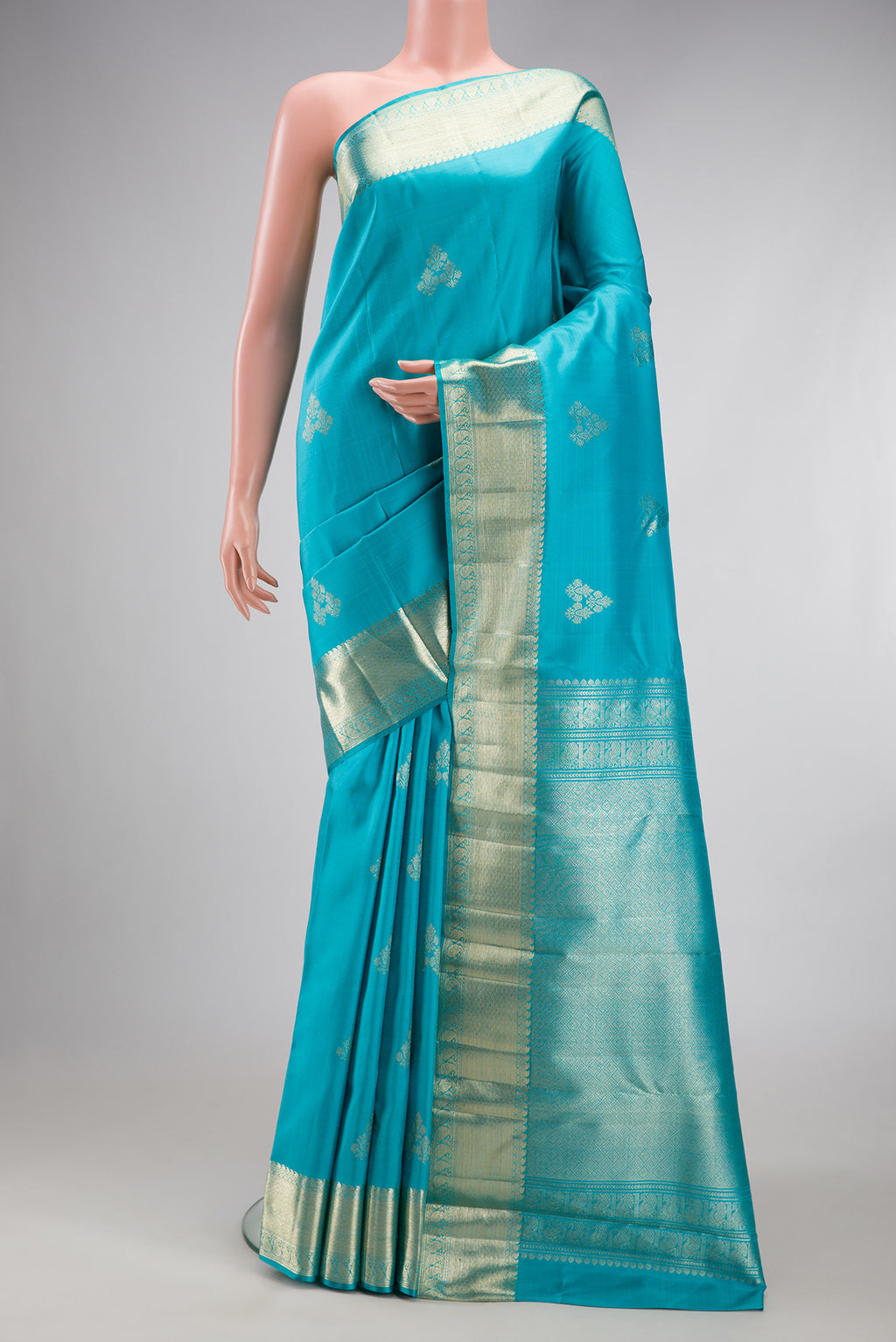 Light Blue Kanjivaram Silk Saree with Zari Butta on the body and Zari Border.  displayed on a mannequin