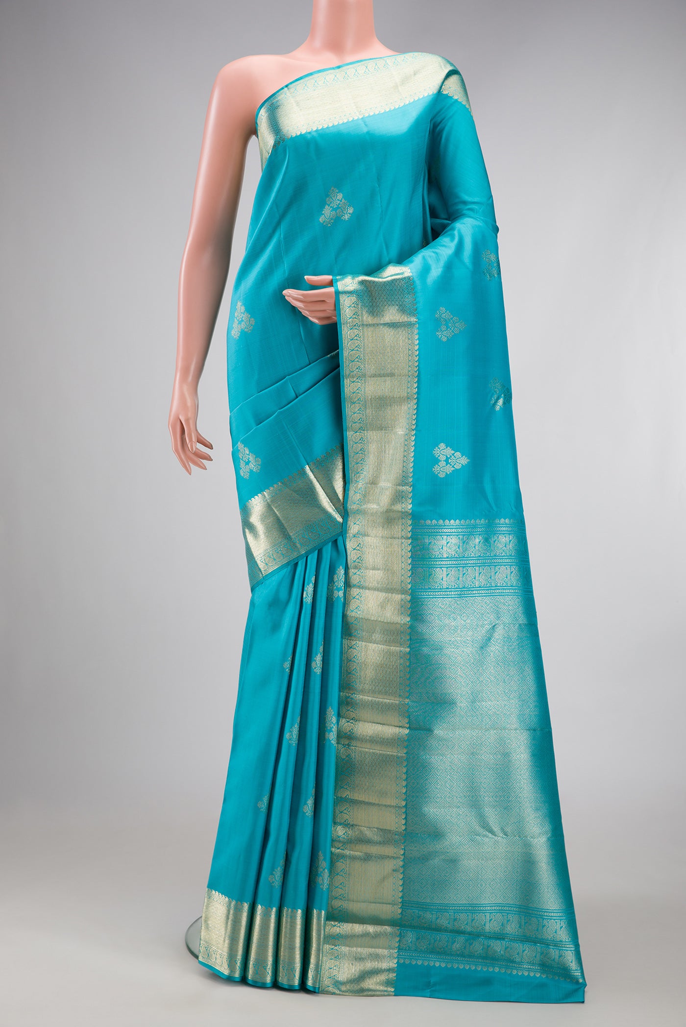 Light Blue Kanjivaram Silk Saree with Zari Butta on the body and Zari Border.  displayed on a mannequin