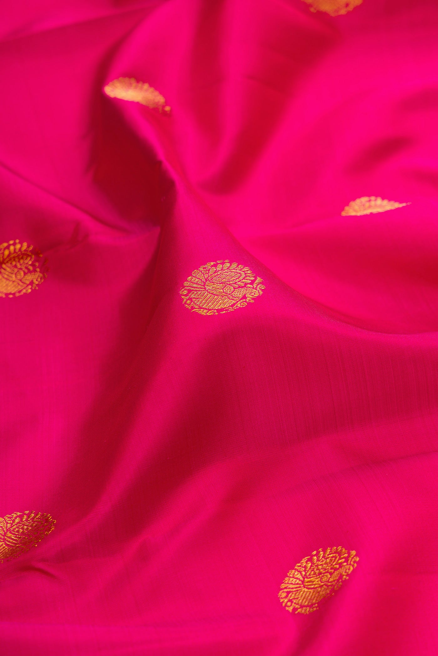 Close up of Pink Kanjivaram Silk Saree with Zari Butta on the body and Zari Border.  displaying folds