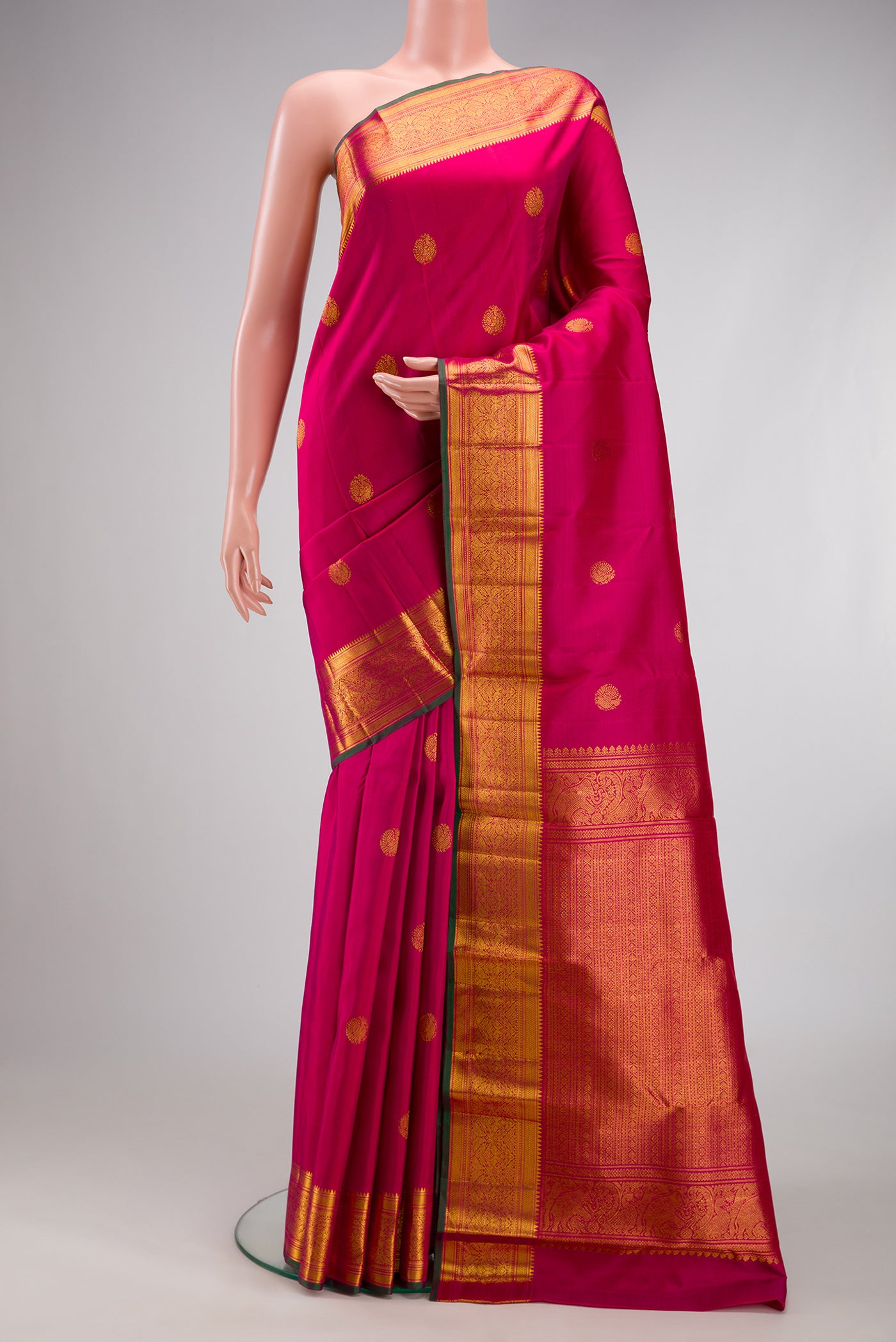 Pink Kanjivaram Silk Saree with Zari Butta on the body and Zari Border.  displayed on a mannequin