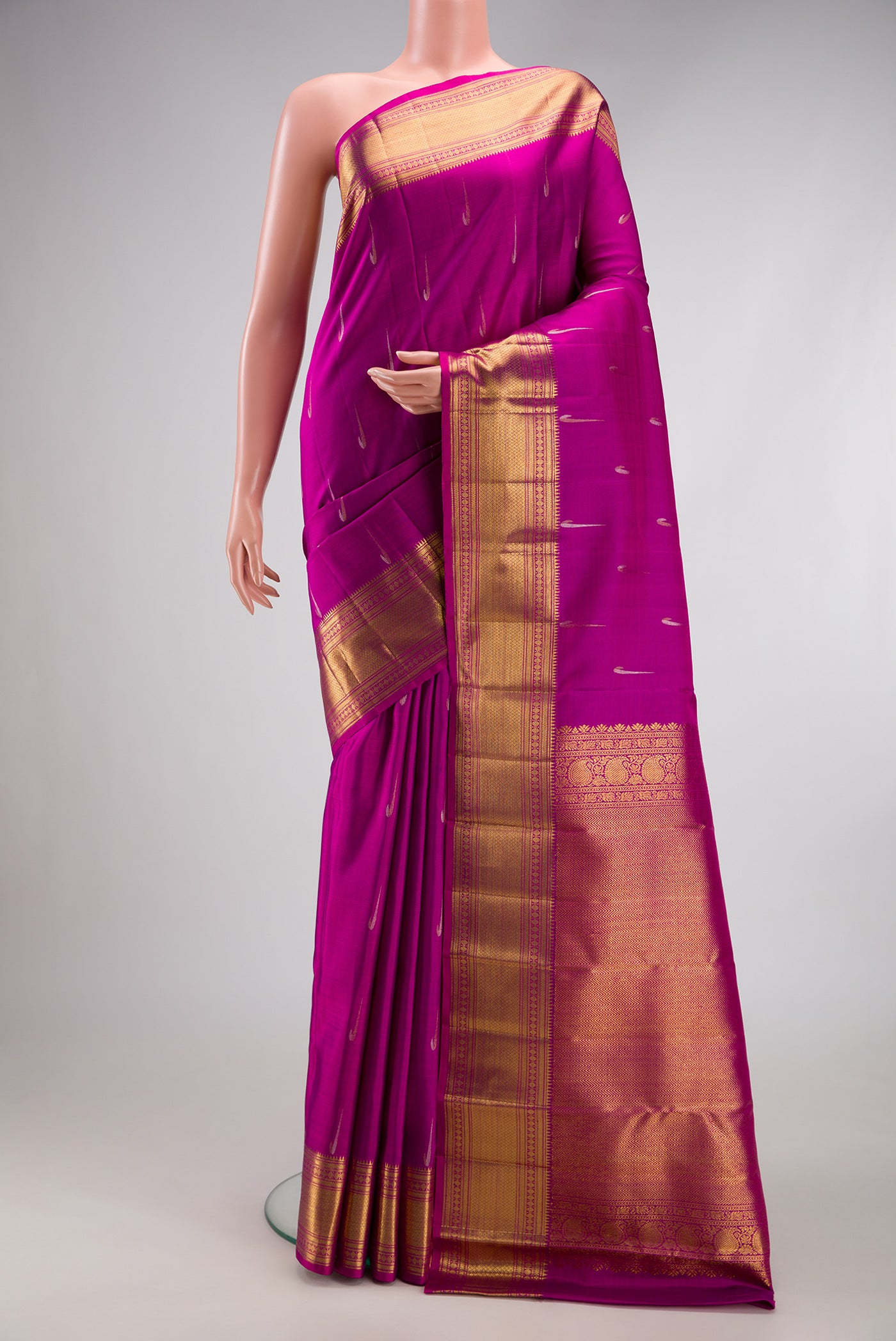 Magenta Kanchipuram Silk Saree with Zari Butta on the body and Zari Border.  displayed on a mannequin