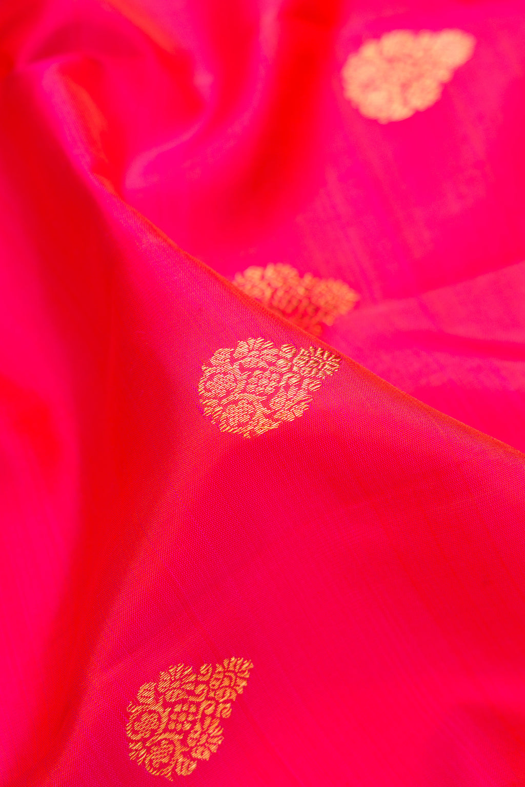 Close up of Pink Kanchipuram Silk Saree with Zari Butta on the body and Zari Border.  displaying folds