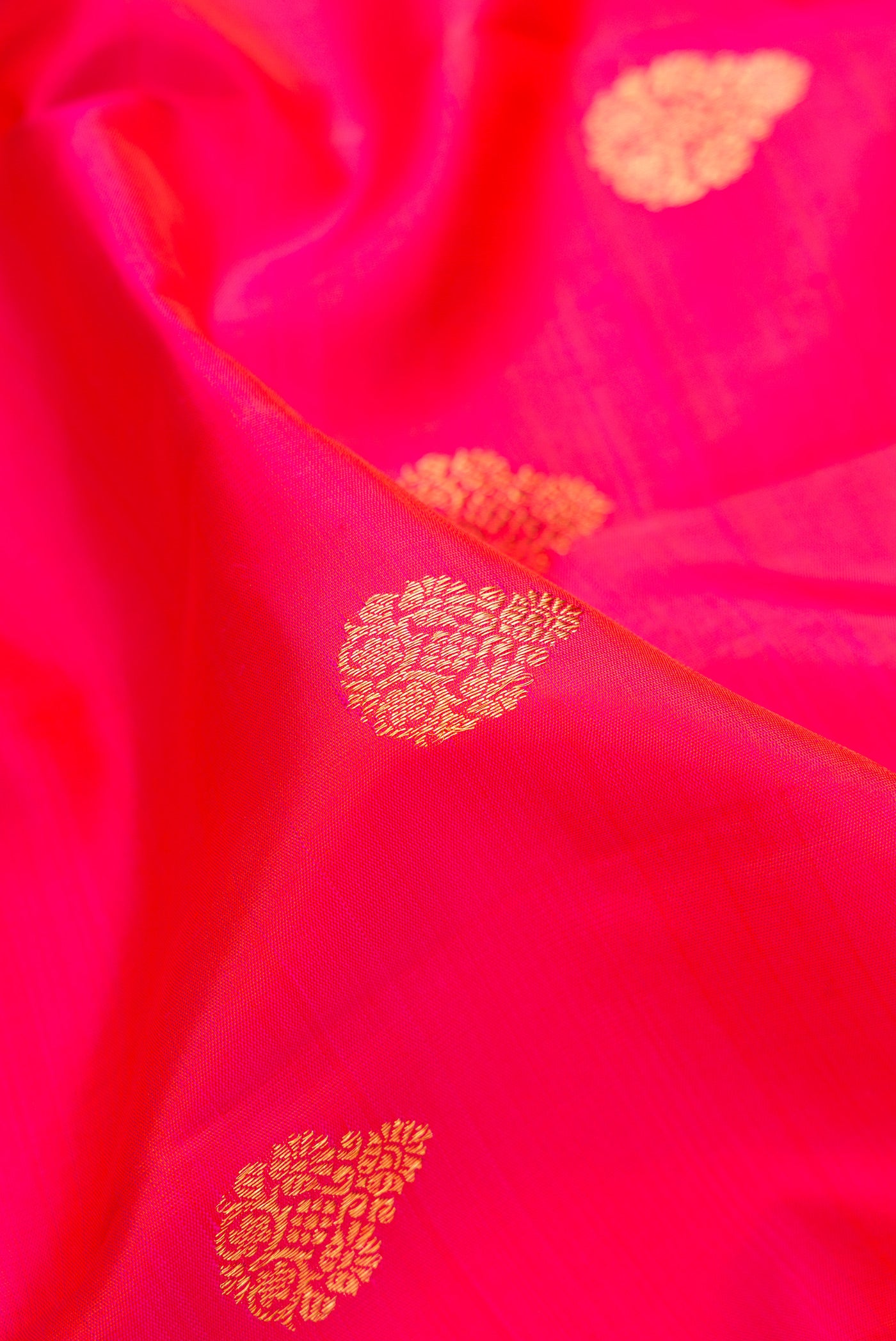 Close up of Pink Kanchipuram Silk Saree with Zari Butta on the body and Zari Border.  displaying folds