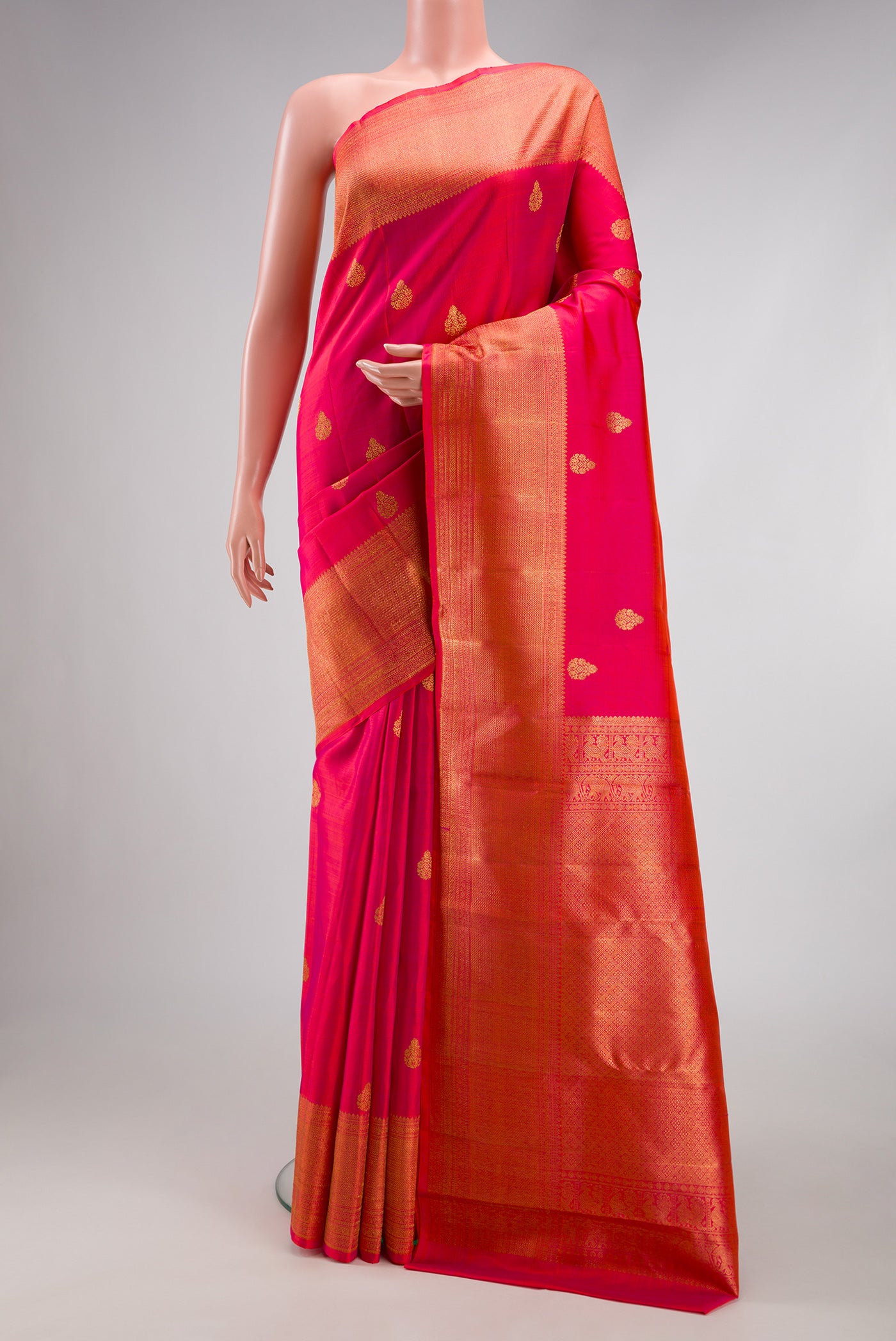 Pink Kanchipuram Silk Saree with Zari Butta on the body and Zari Border.  displayed on a mannequin