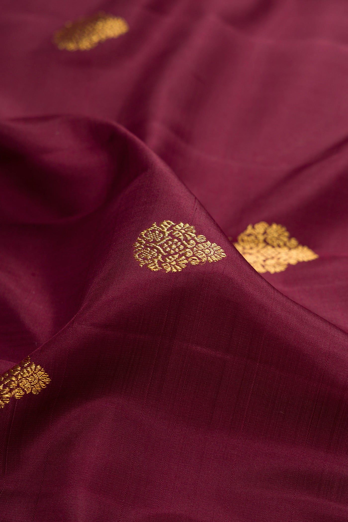 Close up of Coffee Brown Kanchipuram Silk Saree with Zari Butta on the body and Zari Border.  displaying folds