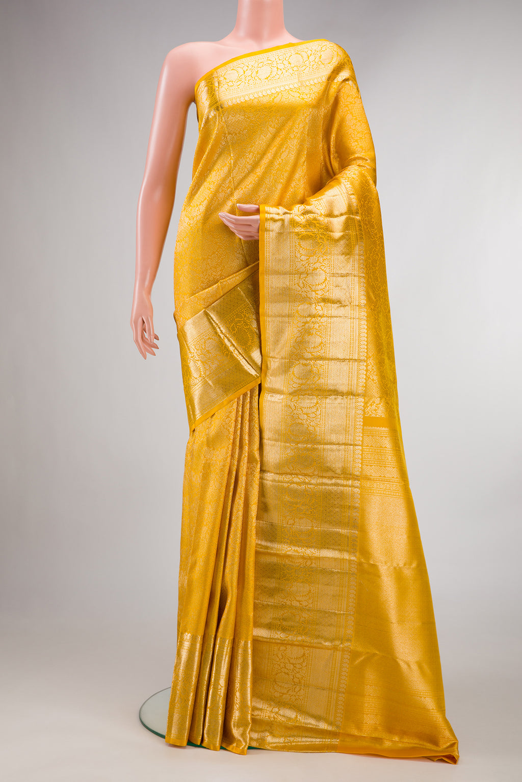 Pure Silk Yellow Kanchipuram Saree with Zari Brocade on the body and Fancy Border.  displayed on a mannequin
