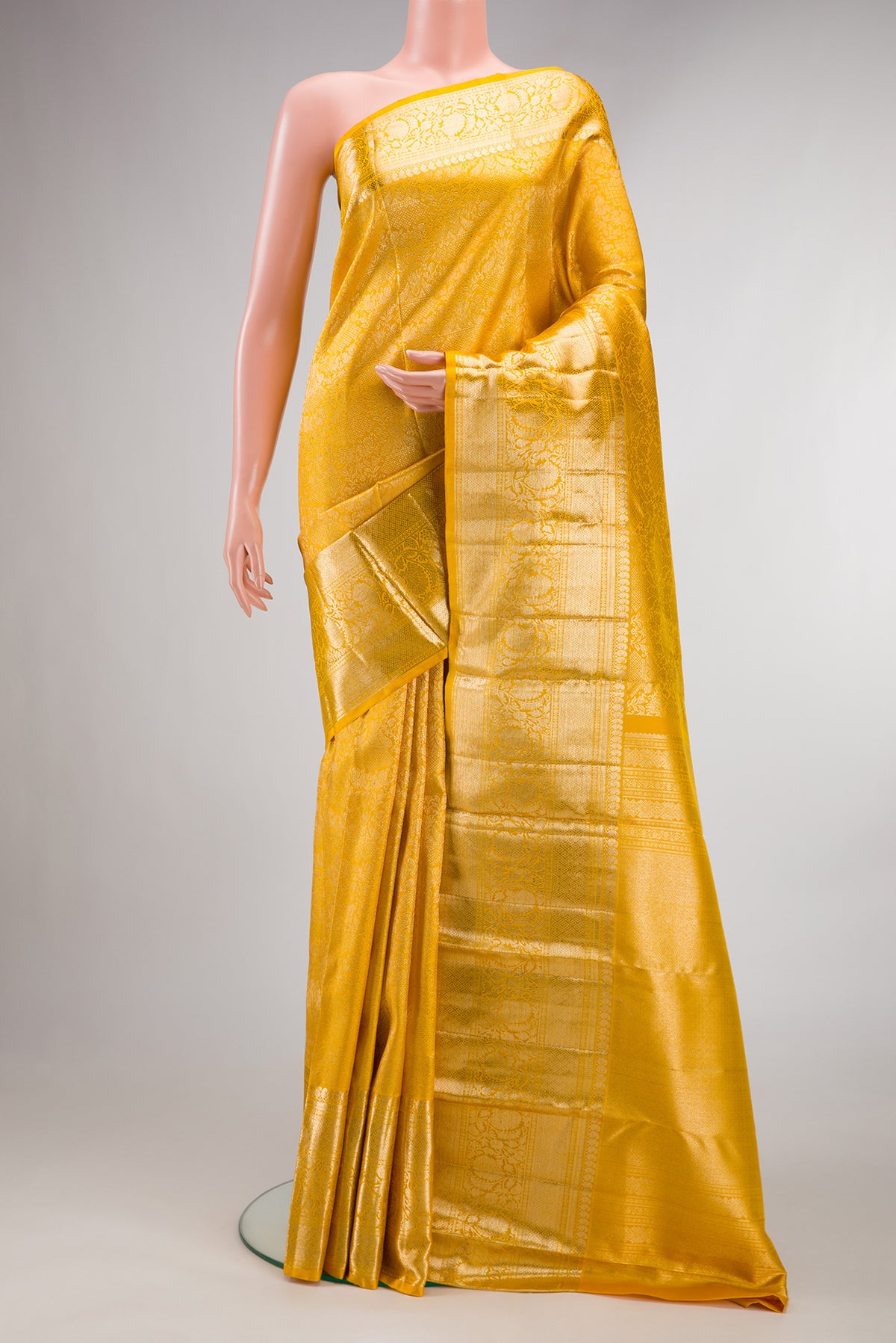 Pure Silk Yellow Kanchipuram Saree with Zari Brocade on the body and Fancy Border.  displayed on a mannequin
