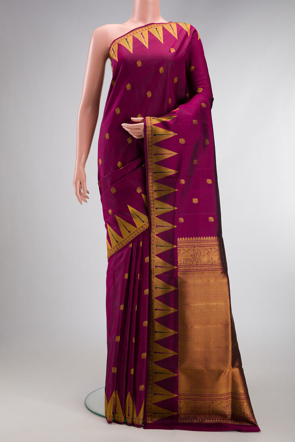 Magenta Kanchipuram Silk Saree with Zari Butta on the body and Temple Border.  displayed on a mannequin