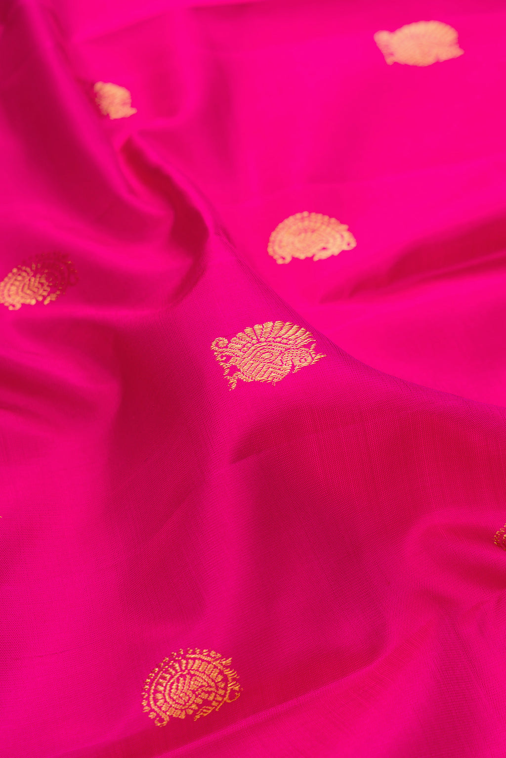 Close up of Dark Pink Kanchipuram Silk Saree with Zari Butta on the body and Fancy Border.  displaying folds