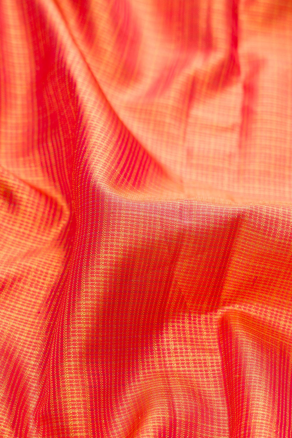 Close up of Orange Kanchipuram Silk Saree with Checked design on the body and Zari Border.  displaying folds