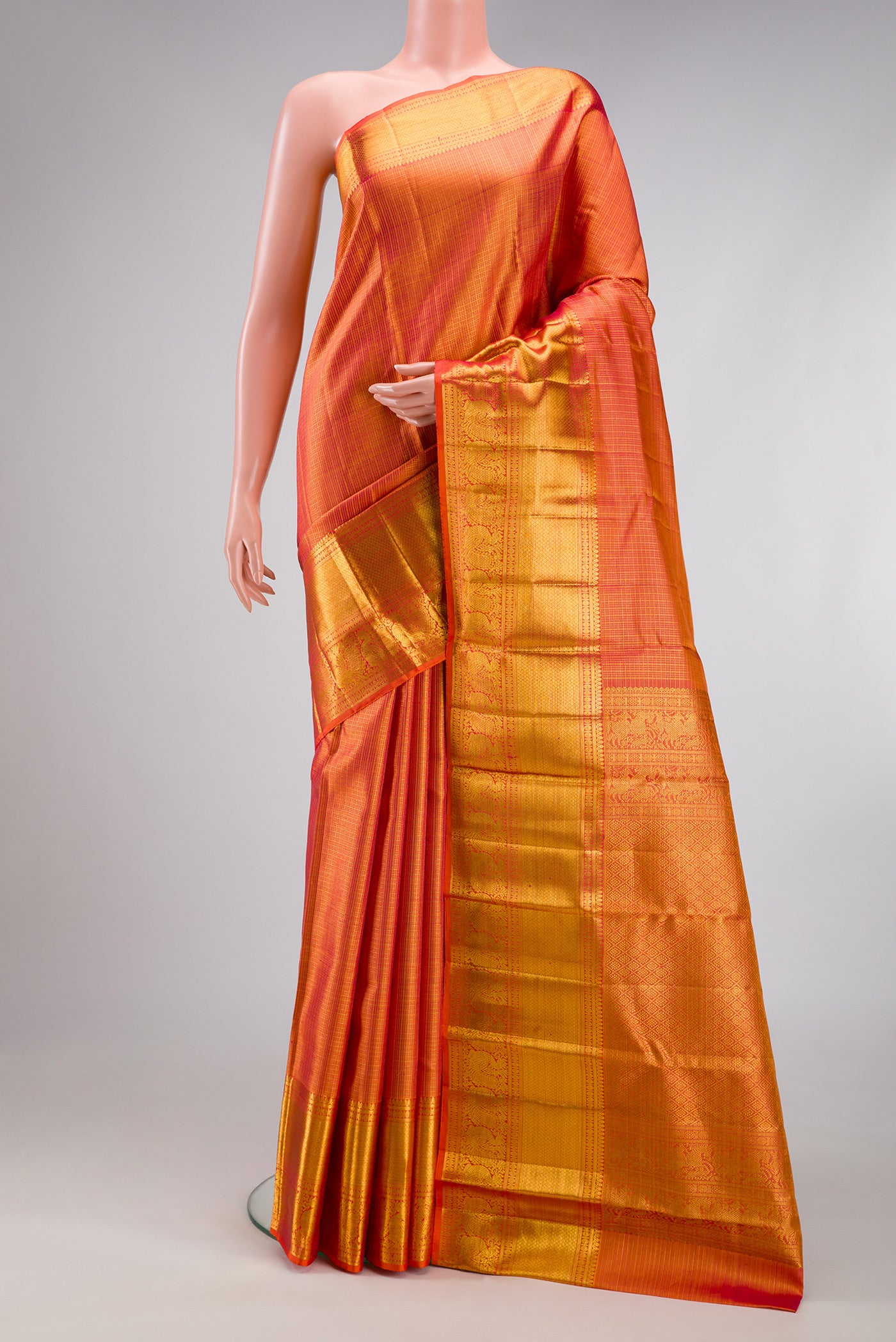 Orange Kanchipuram Silk Saree with Checked design on the body and Zari Border.  displayed on a mannequin