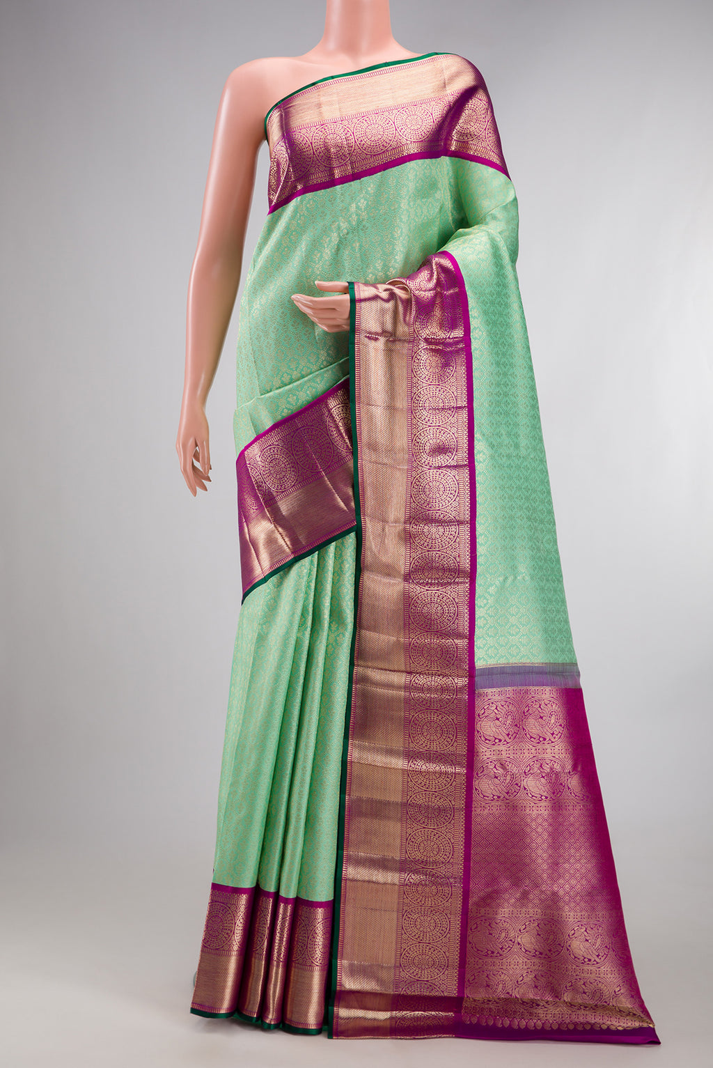 Pure Silk Green Kanchipuram Saree with Zari Brocade on the body and Zari Border.  displayed on a mannequin