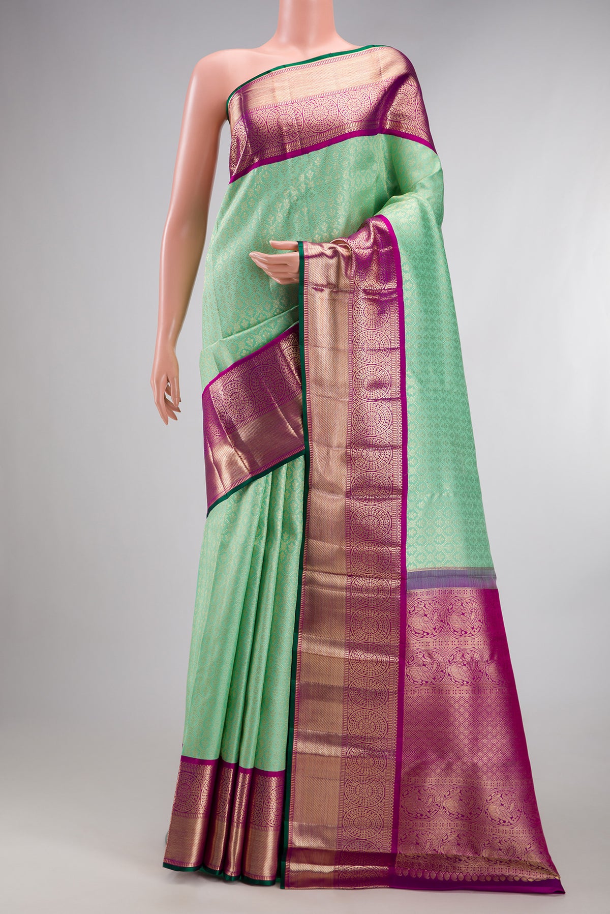 Pure Silk Green Kanchipuram Saree with Zari Brocade on the body and Zari Border.  displayed on a mannequin