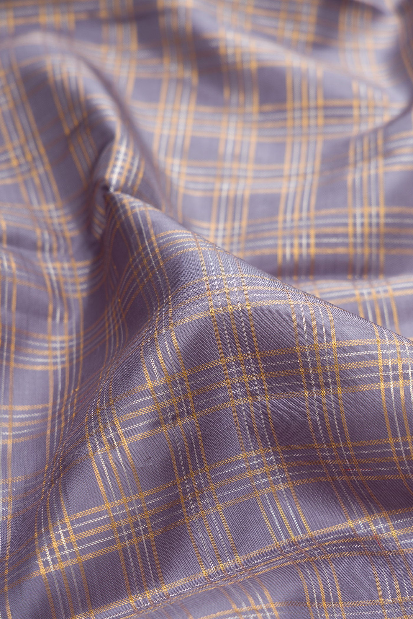 Close up of Grey Kanchipuram Silk Saree with Checked design on the body and Zari Border.  displaying folds