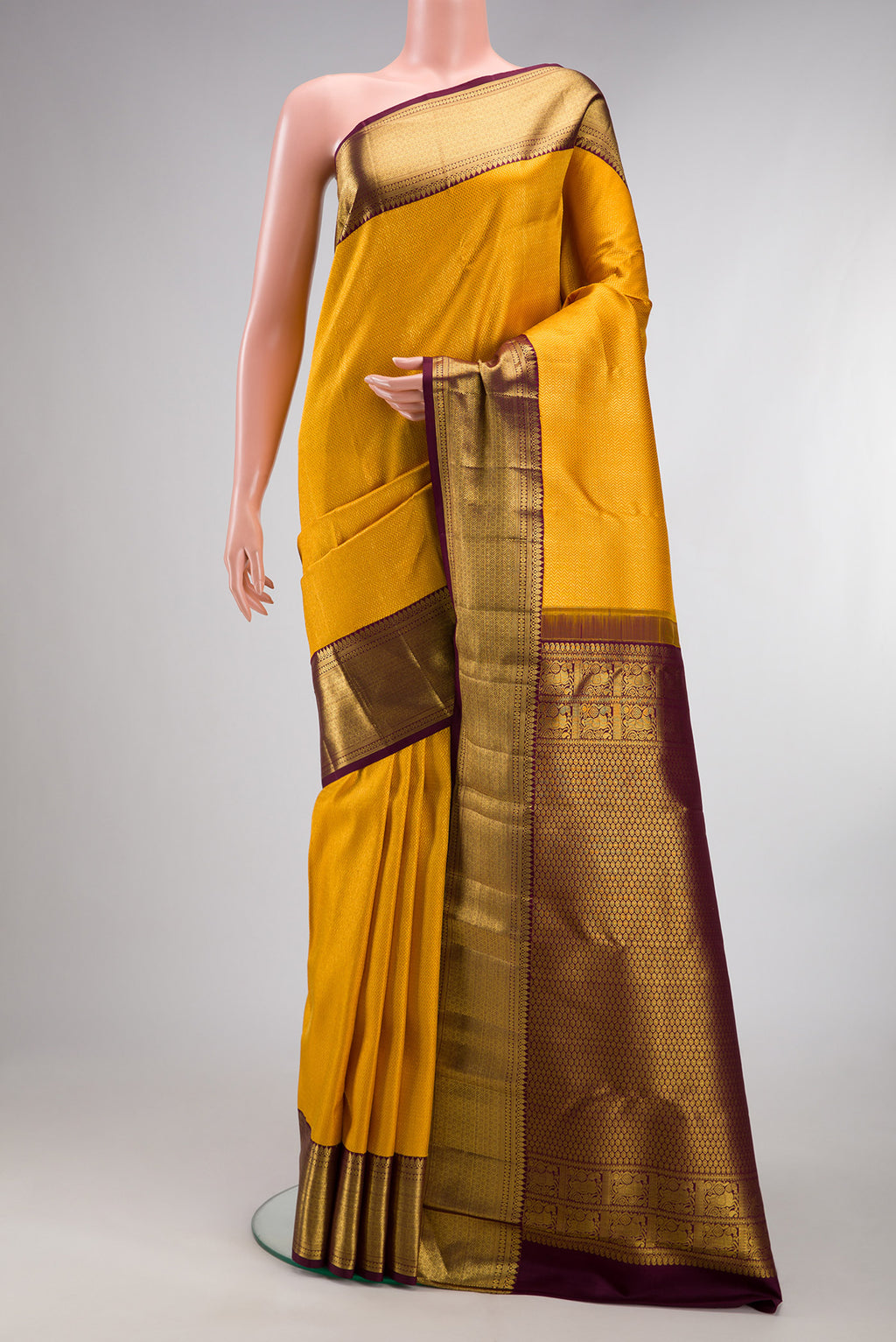 Pure Silk Yellow Kanchipuram Saree with Zari Brocade on the body and Zari Border.  displayed on a mannequin