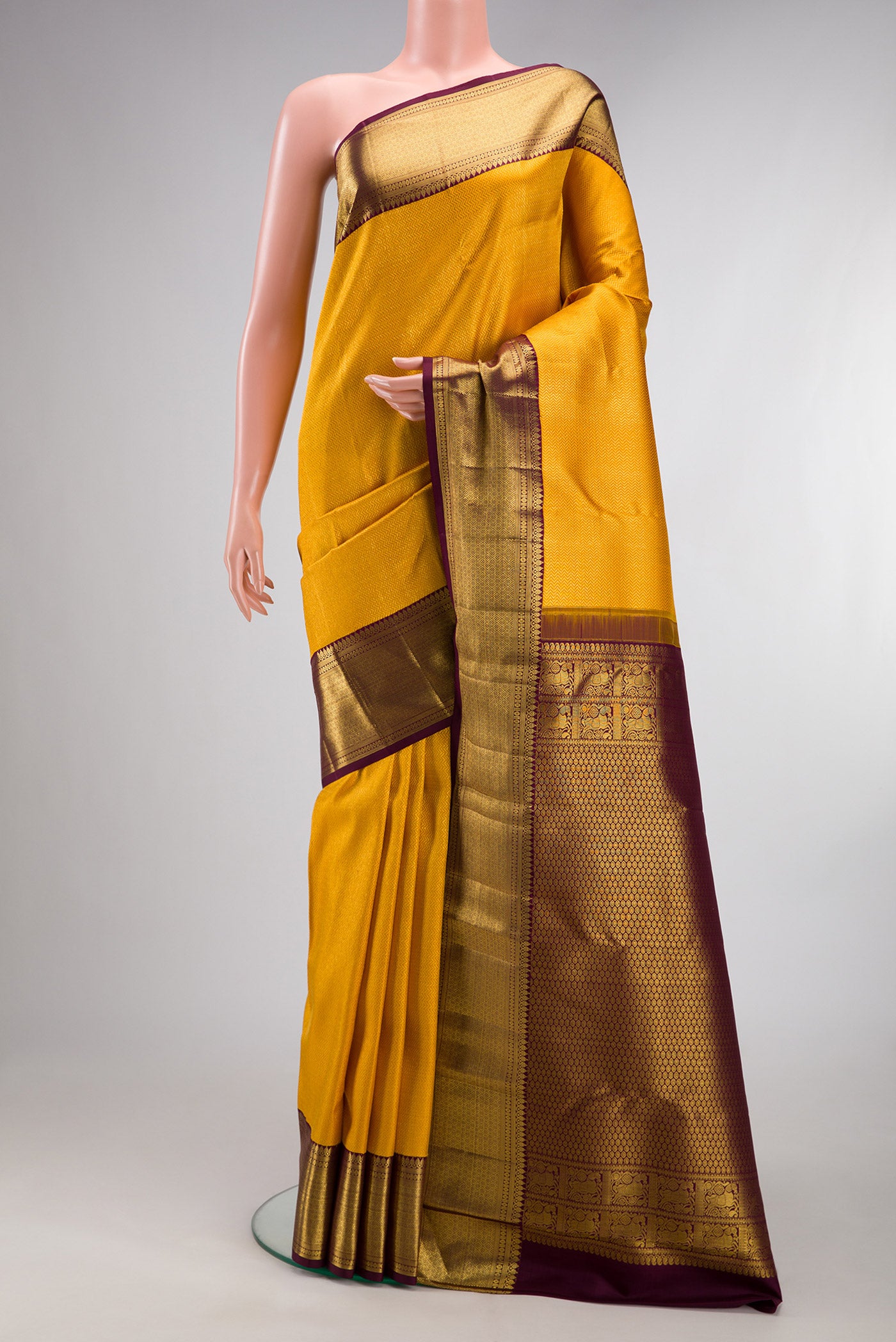 Pure Silk Yellow Kanchipuram Saree with Zari Brocade on the body and Zari Border.  displayed on a mannequin