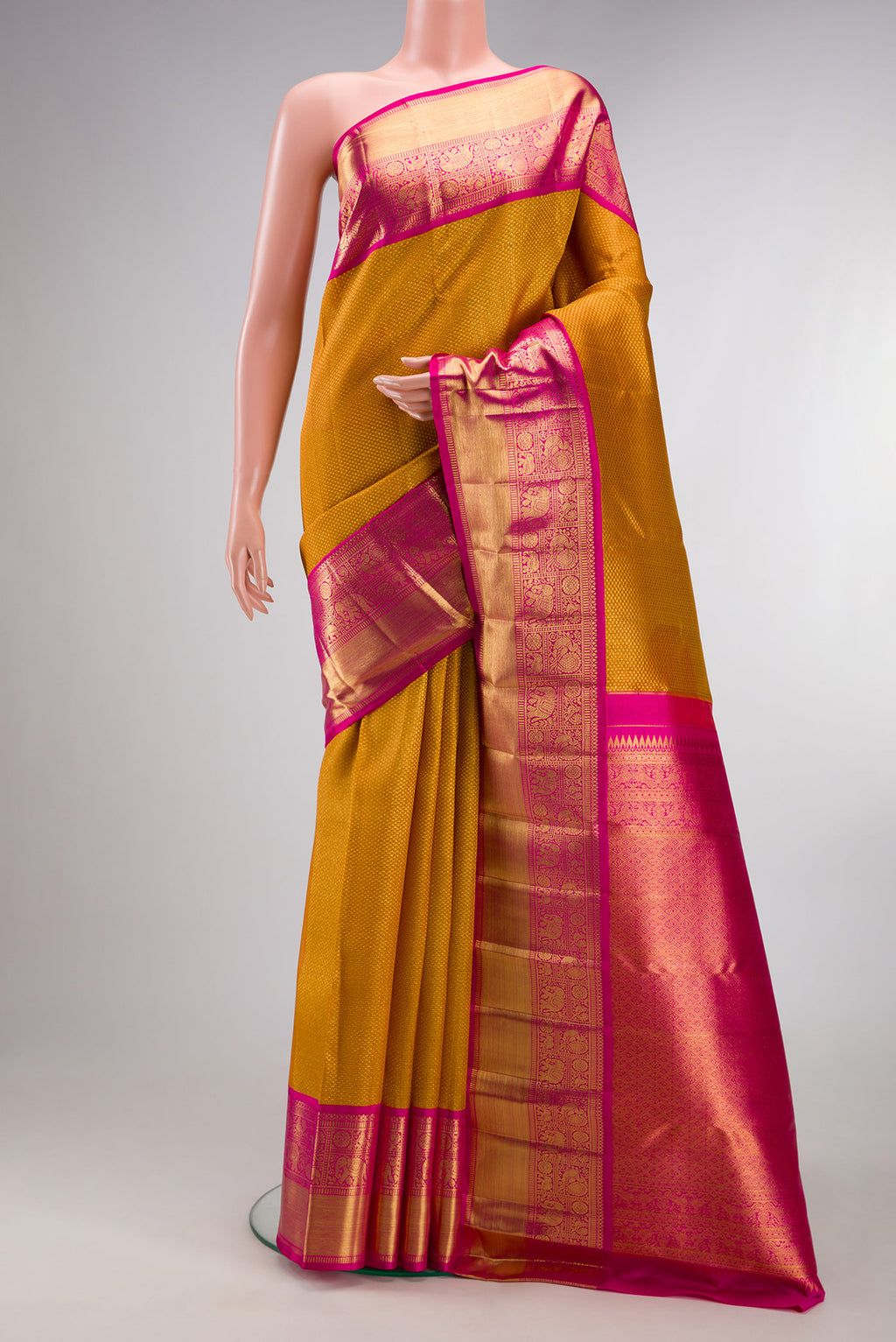 Mustard Kanchipuram Tissue Saree with Zari Brocade on the body and Zari Border.  displayed on a mannequin