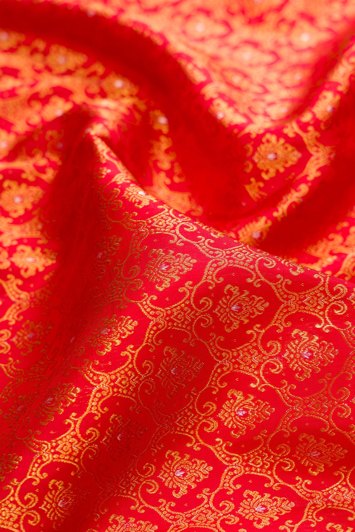 Close up of Pure Silk Red Kanchipuram Saree with Zari Brocade on the body and Fancy Border.  displaying folds