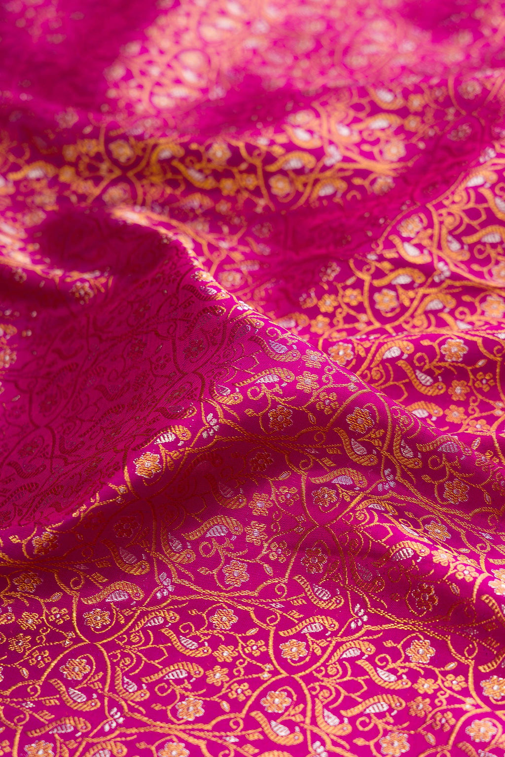 Close up of Magenta Kanchipuram Silk Saree with Zari Brocade on the body and Zari Border.  displaying folds