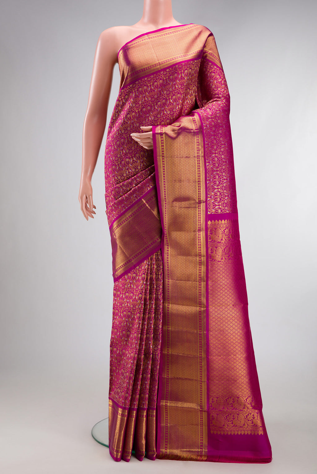 Magenta Kanchipuram Silk Saree with Zari Brocade on the body and Zari Border.  displayed on a mannequin