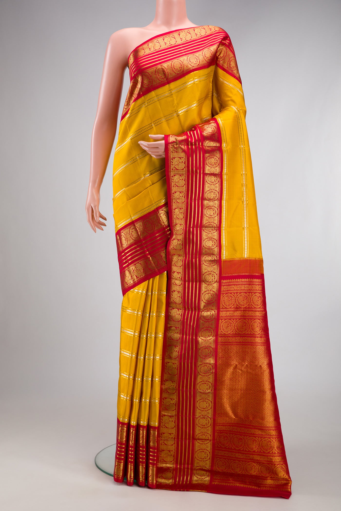 Yellow Kanchipuram Silk Saree with Stripes on the body and Zari Border.  displayed on a mannequin