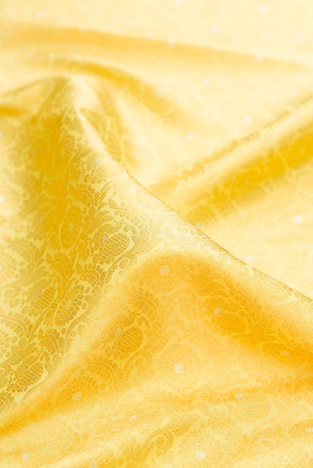 Close up of Pure Silk Lemon Yellow Kanchipuram Saree with Zari Brocade on the body and Zari Border.  displaying folds