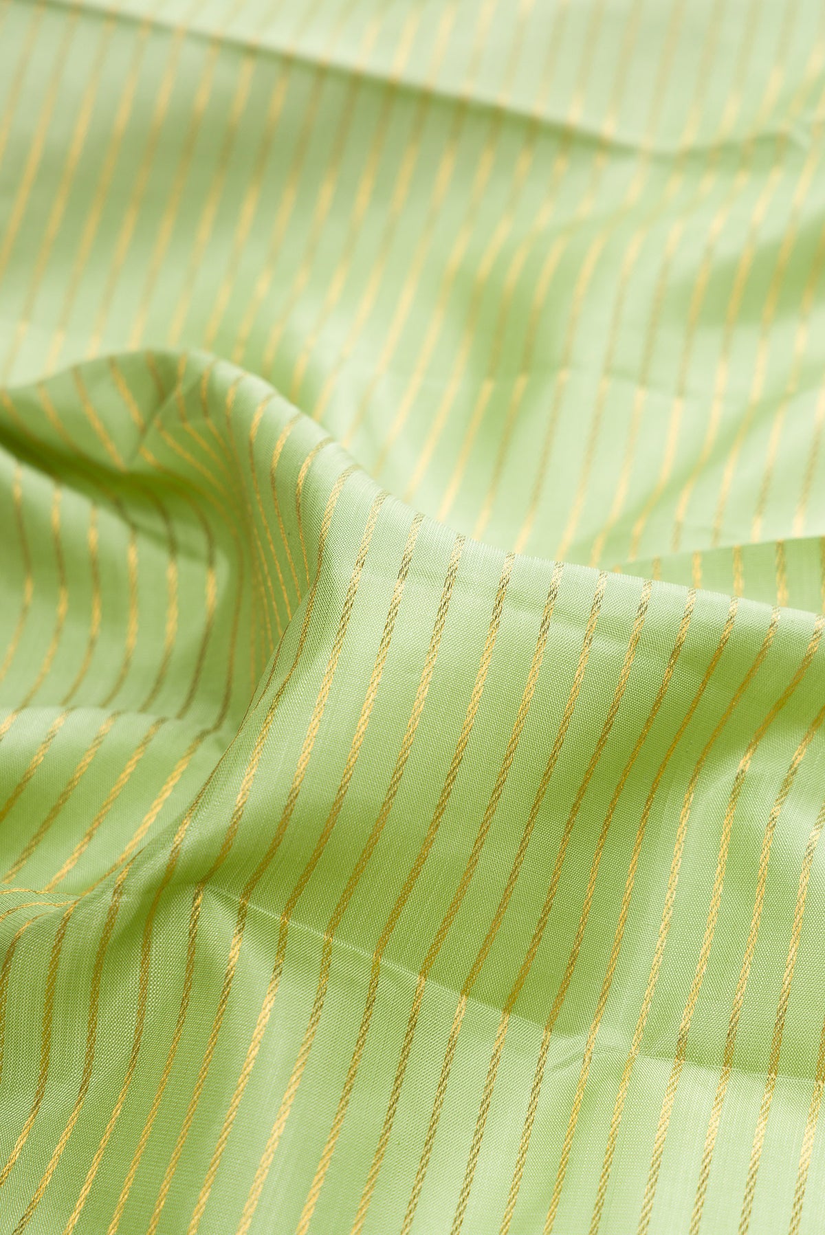 Close up of Pure Silk Pista Green Kanchipuram Saree with Stripes on the body and Zari Border.  displaying folds
