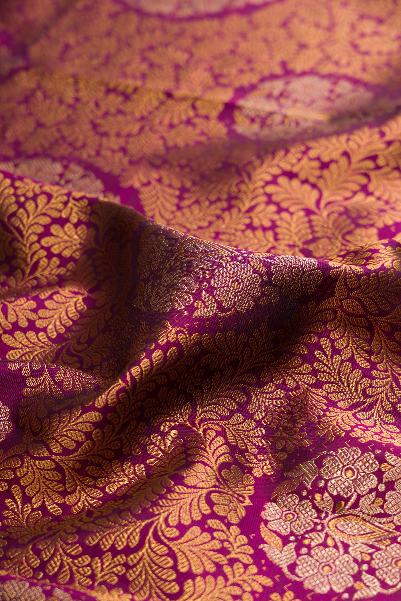 Close up of Pure Silk Magenta Kanjivaram Saree with Zari Brocade on the body and Zari Border.  displaying folds