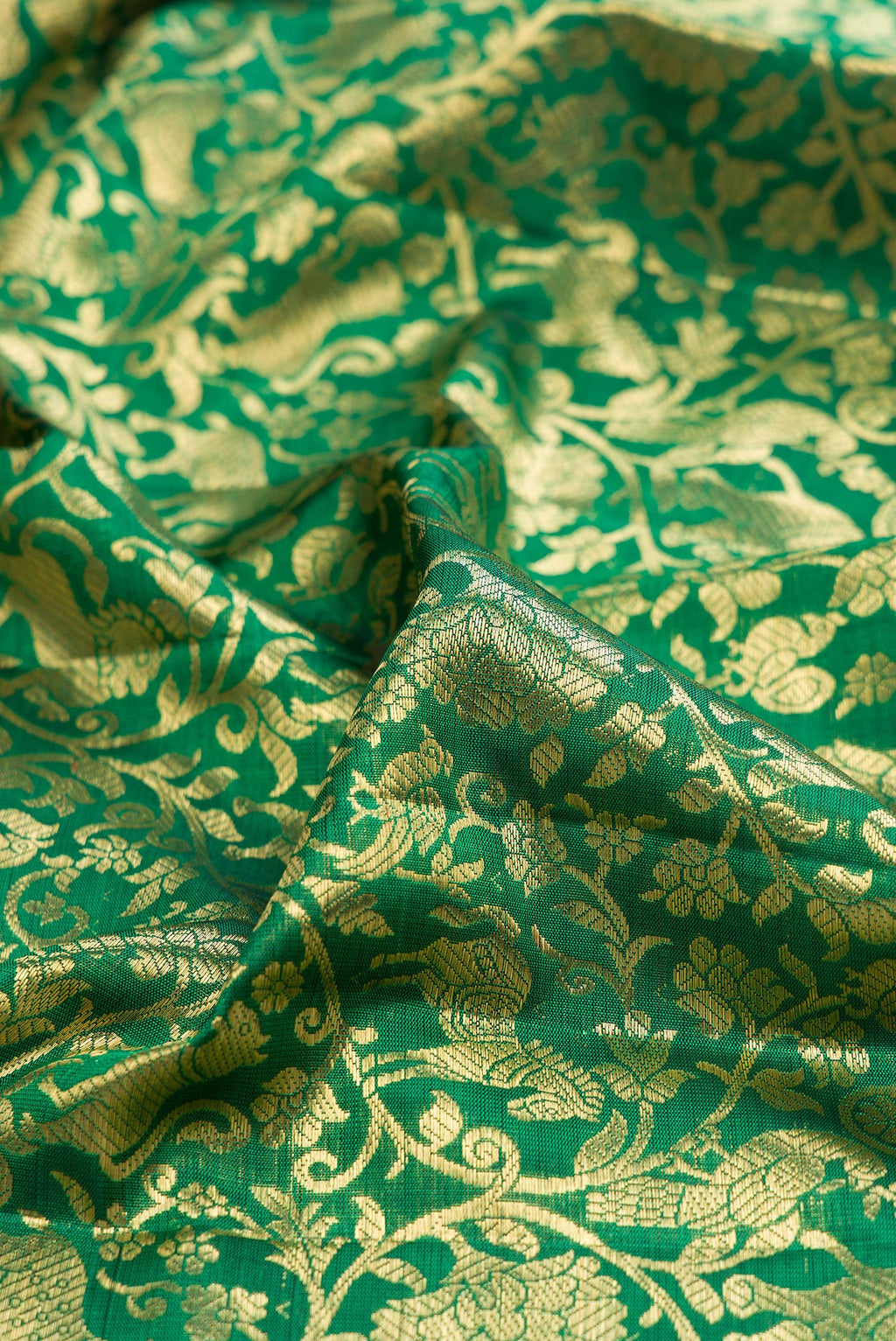 Close up of Green Kanjivaram Silk Saree with Zari Brocade on the body and Zari Border.  displaying folds