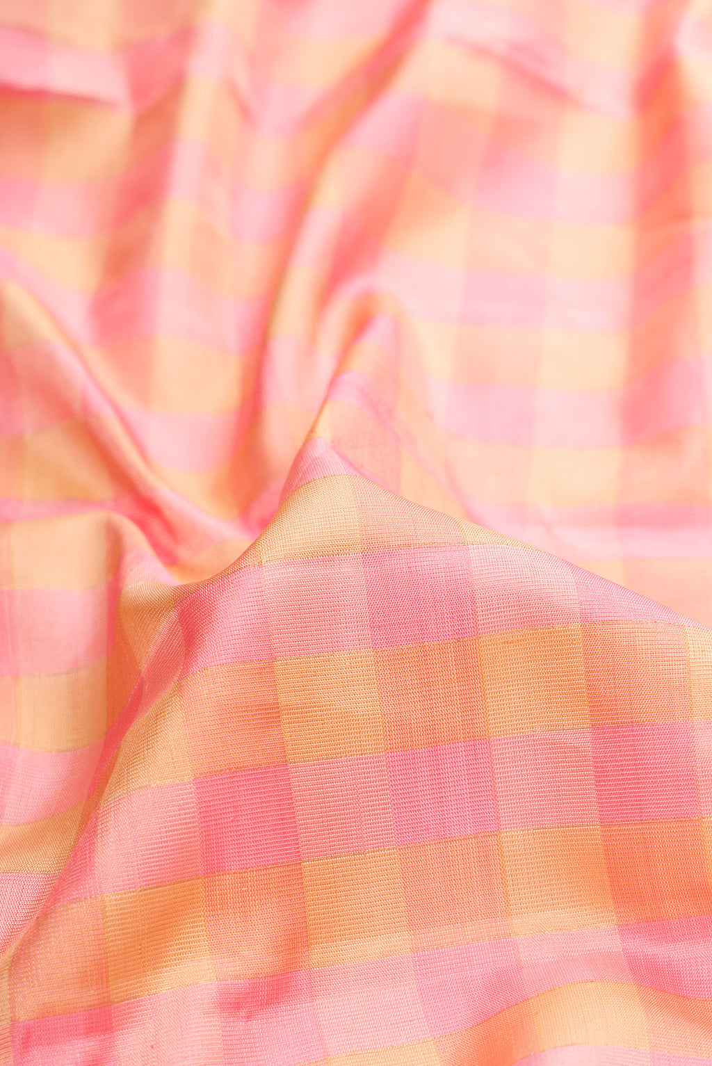 Close up of Pure Silk Rose pink Kanjivaram Tissue Saree with Checked design on the body and Zari Border.  displaying folds