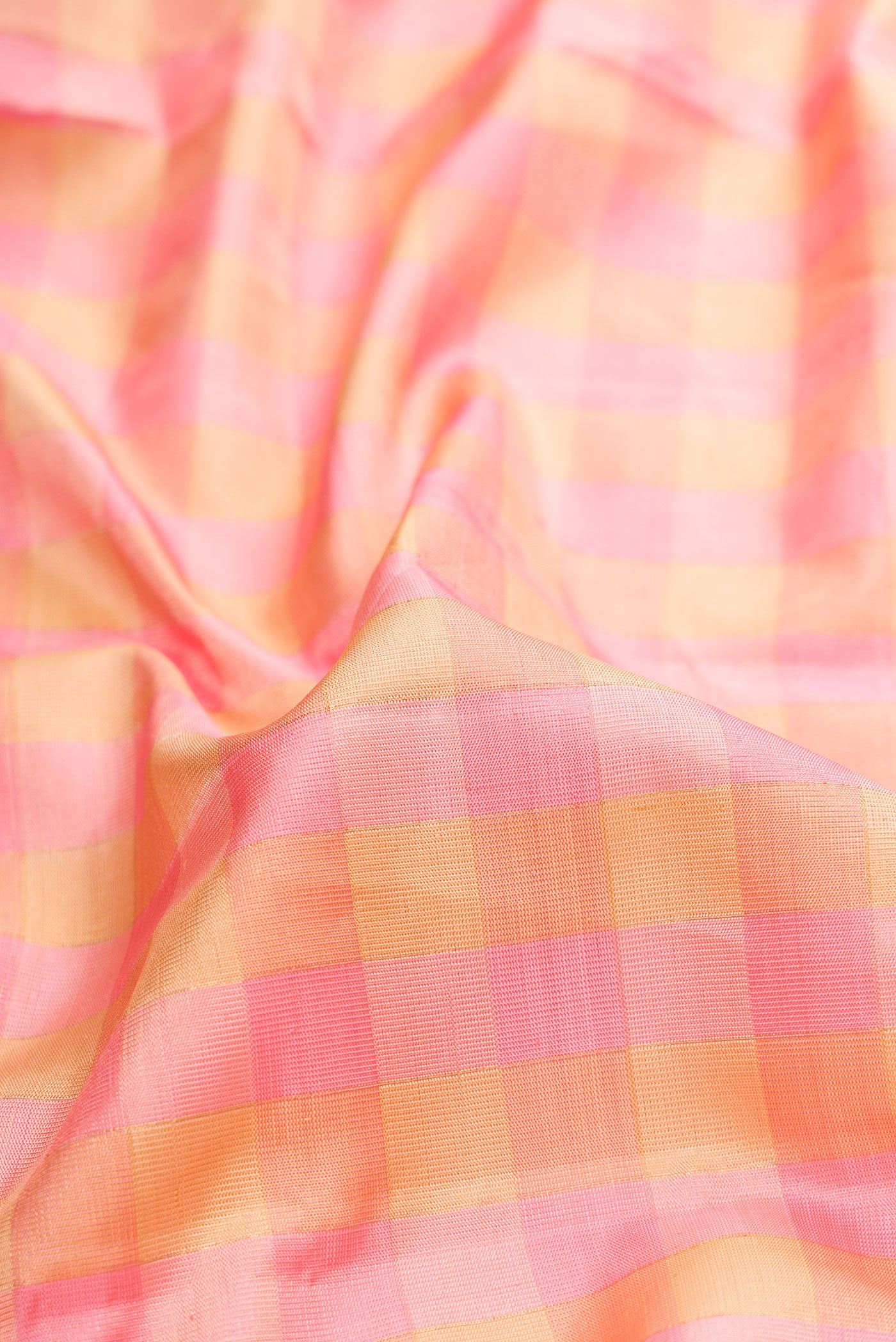 Close up of Pure Silk Rose pink Kanjivaram Tissue Saree with Checked design on the body and Zari Border.  displaying folds