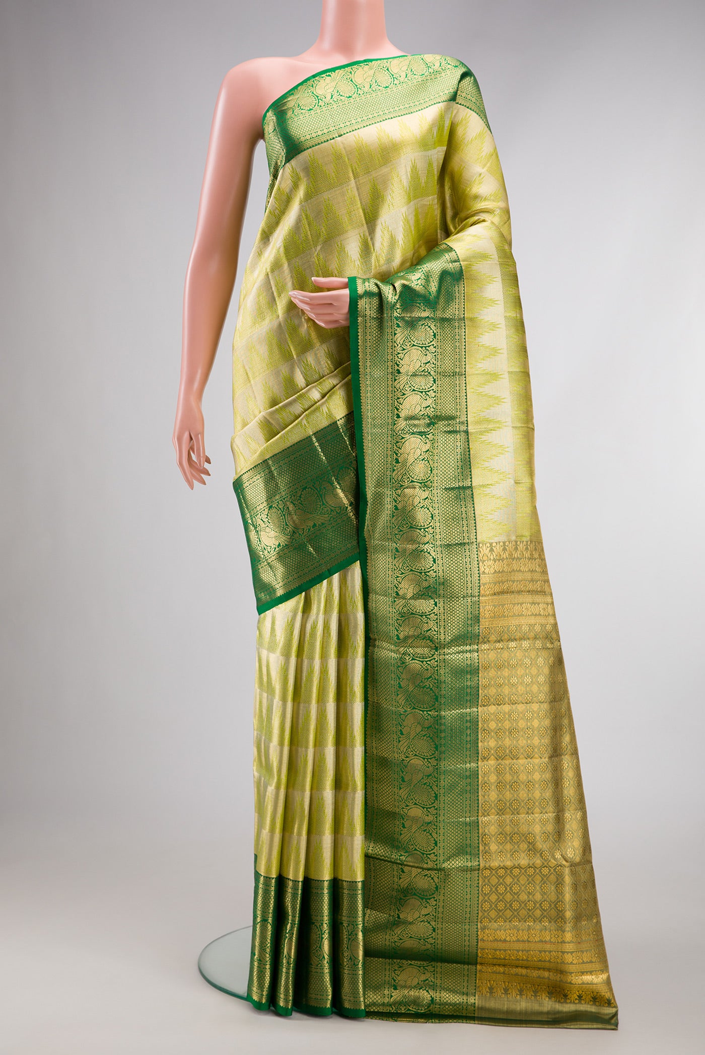 Parrot Green Dual Tone Kanjivaram Tissue Silk Saree with Zari Brocade on the body and Fancy Border.  displayed on a mannequin