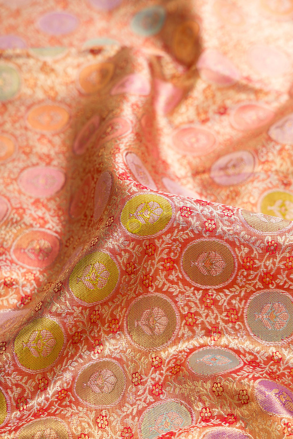 Close up of Pure Silk Golden Peach Dual Tone Kanjivaram Tissue Saree with Zari Brocade on the body and Zari Border.  displaying folds