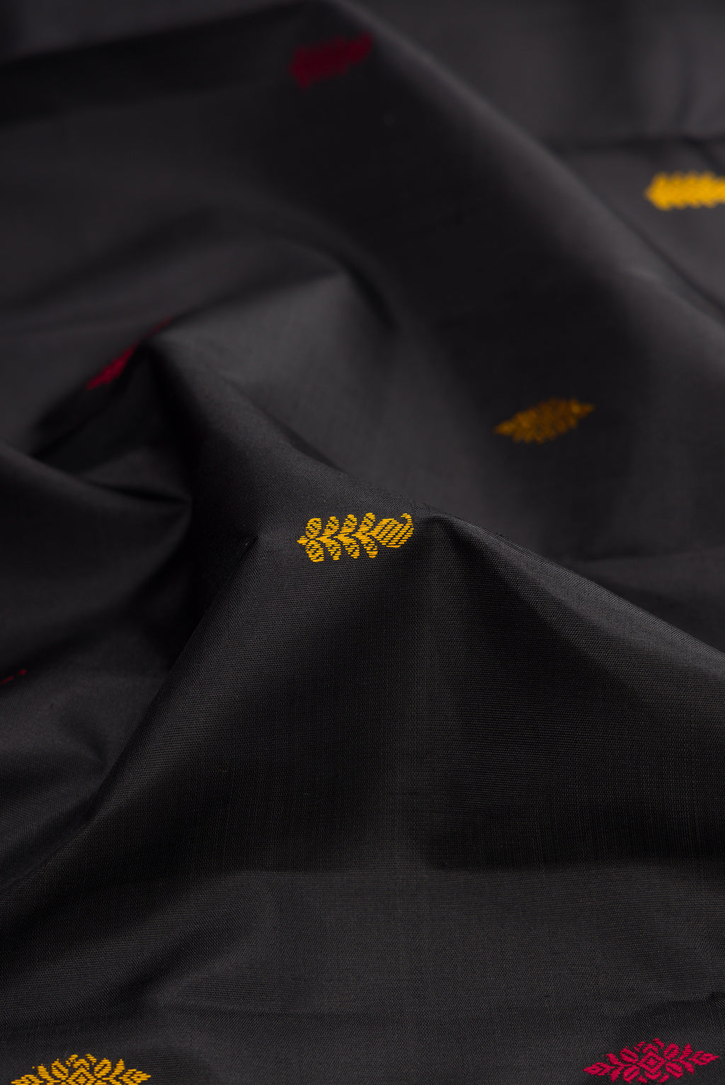 Close up of Black Kanjivaram Silk Saree with Thread Butta on the body and Ganga Jamuna Border.  displaying folds