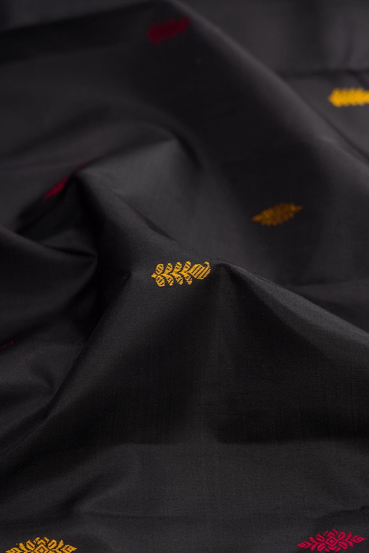 Close up of Black Kanjivaram Silk Saree with Thread Butta on the body and Ganga Jamuna Border.  displaying folds