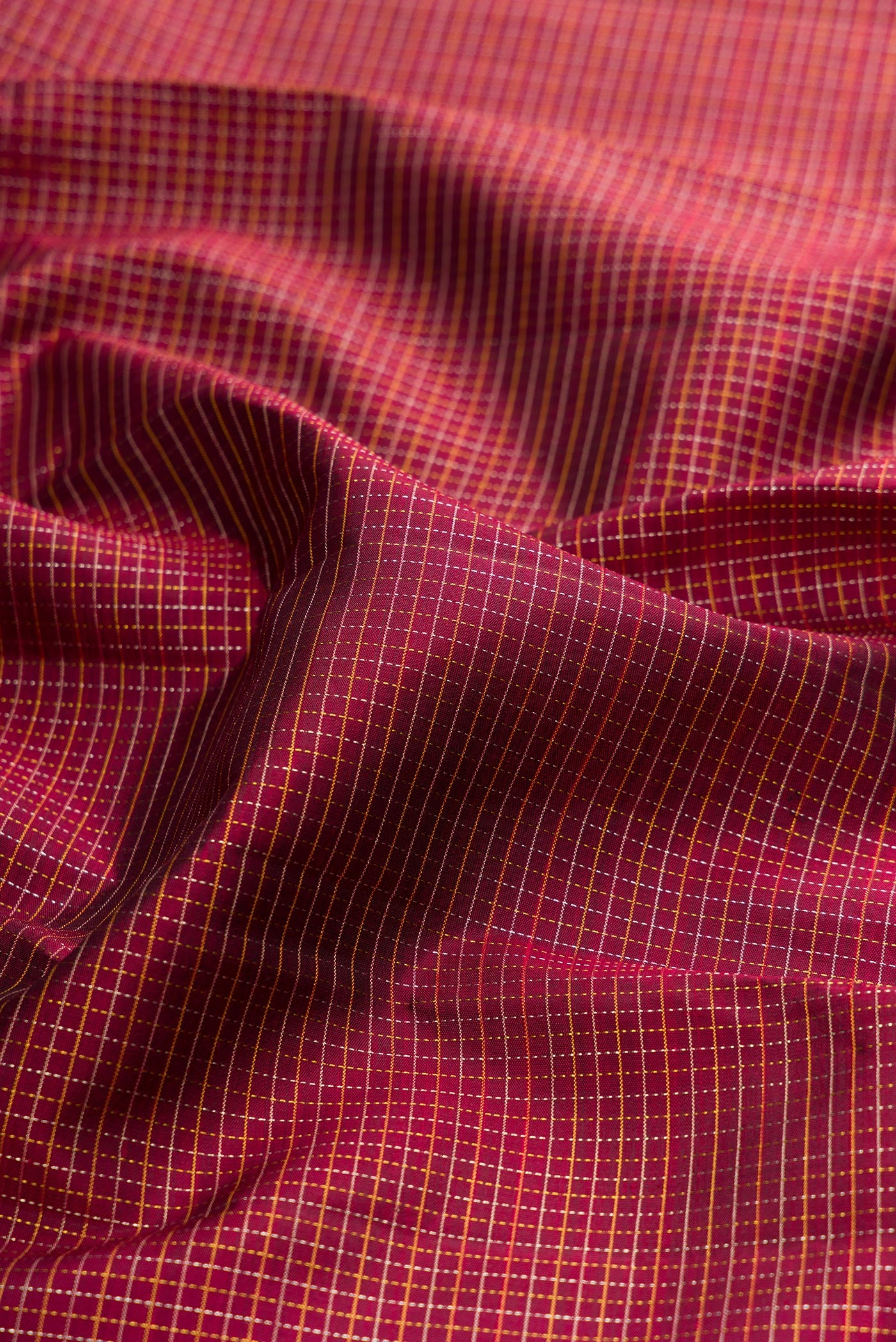 Close up of Maroon Kanchipuram Silk Saree with Stripes on the body and Zari Border.  displaying folds