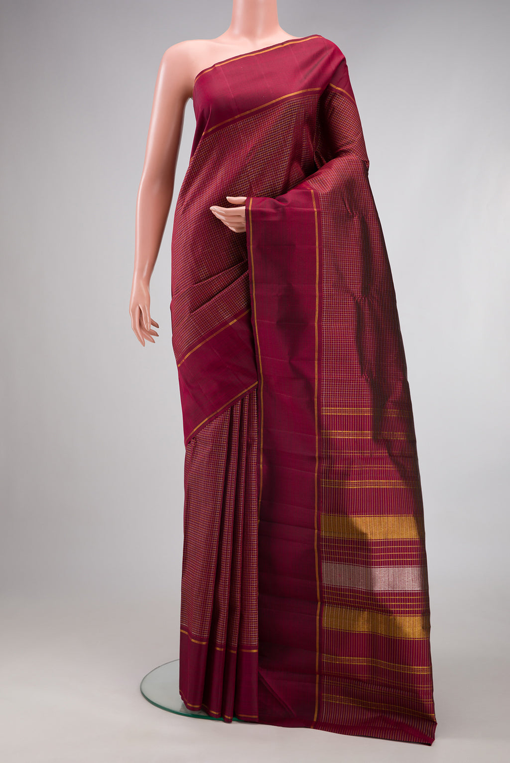 Maroon Kanchipuram Silk Saree with Stripes on the body and Zari Border.  displayed on a mannequin